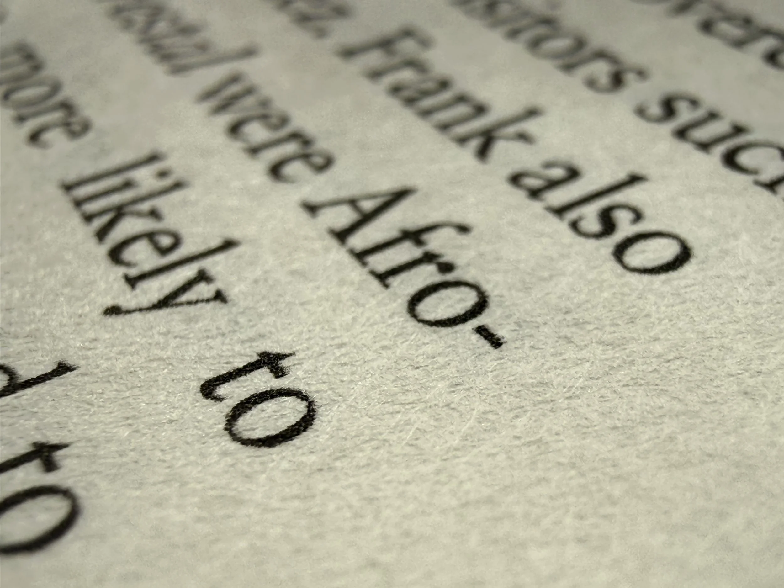Close-up of printed black text on off-white paper