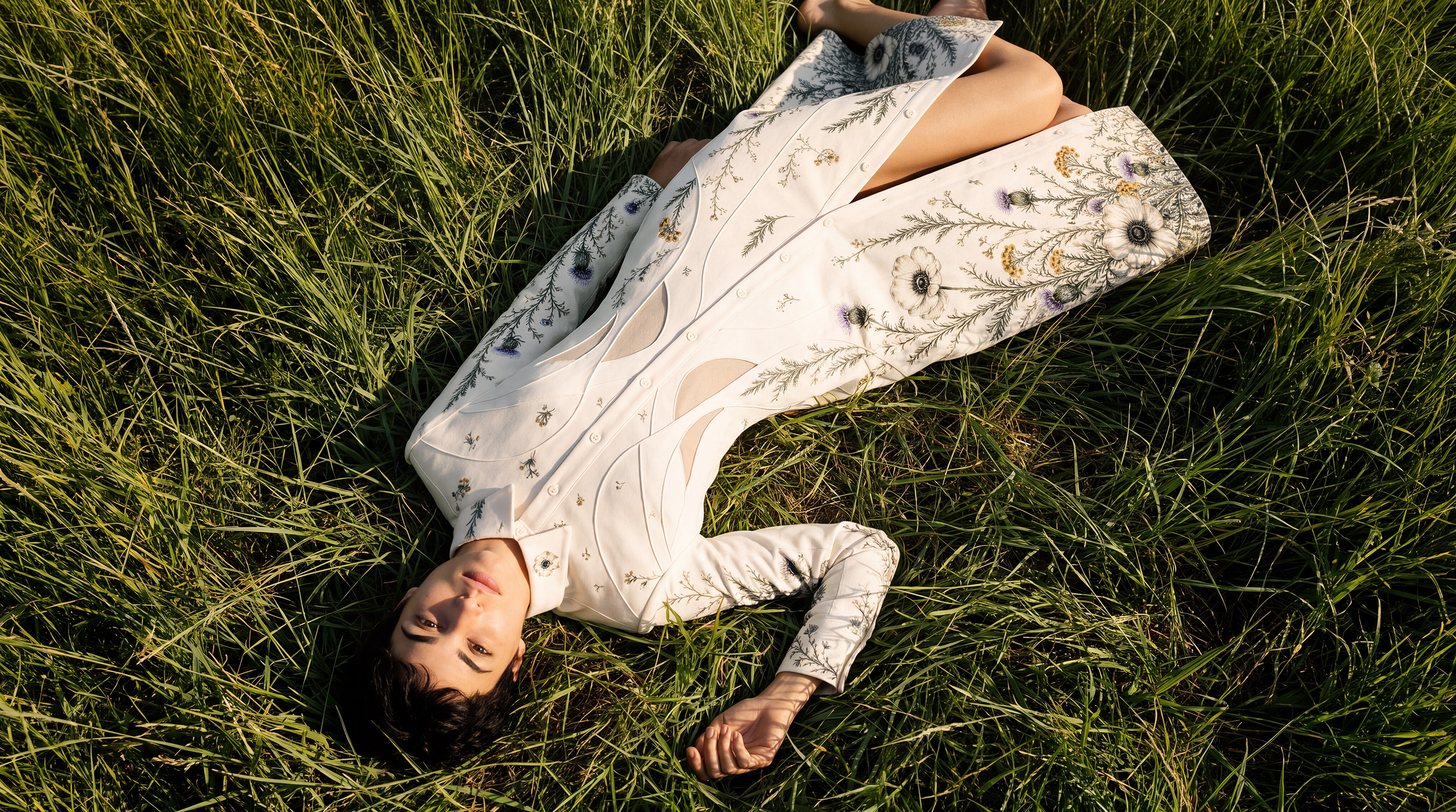 Ivory embroidered sculptural clothing photographed on grass