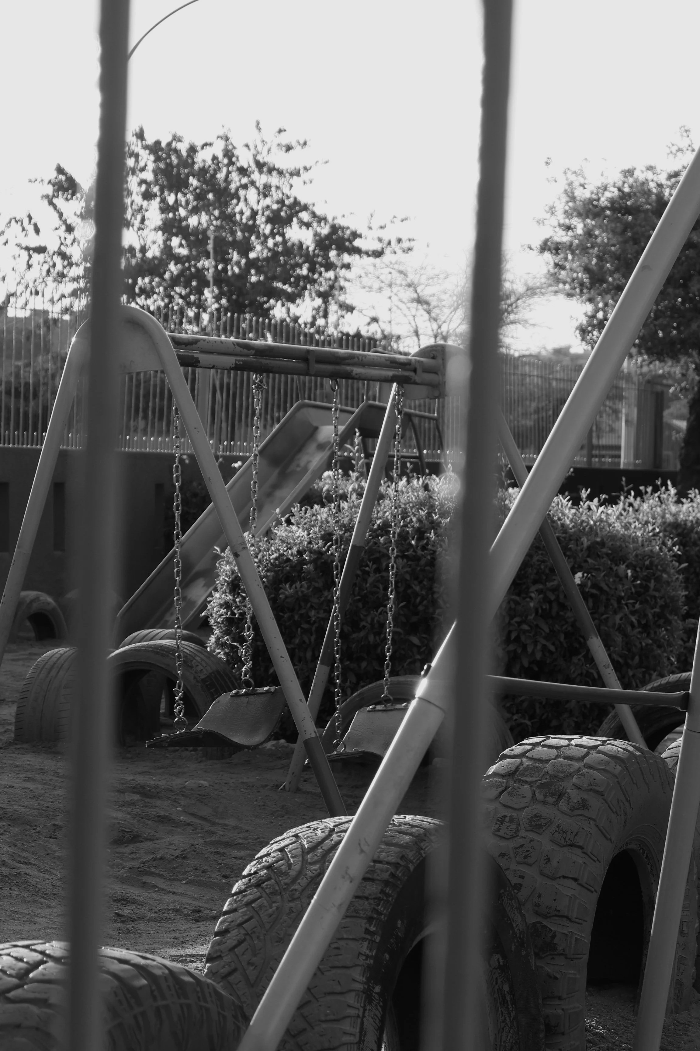 Black and white photograph of a swing set