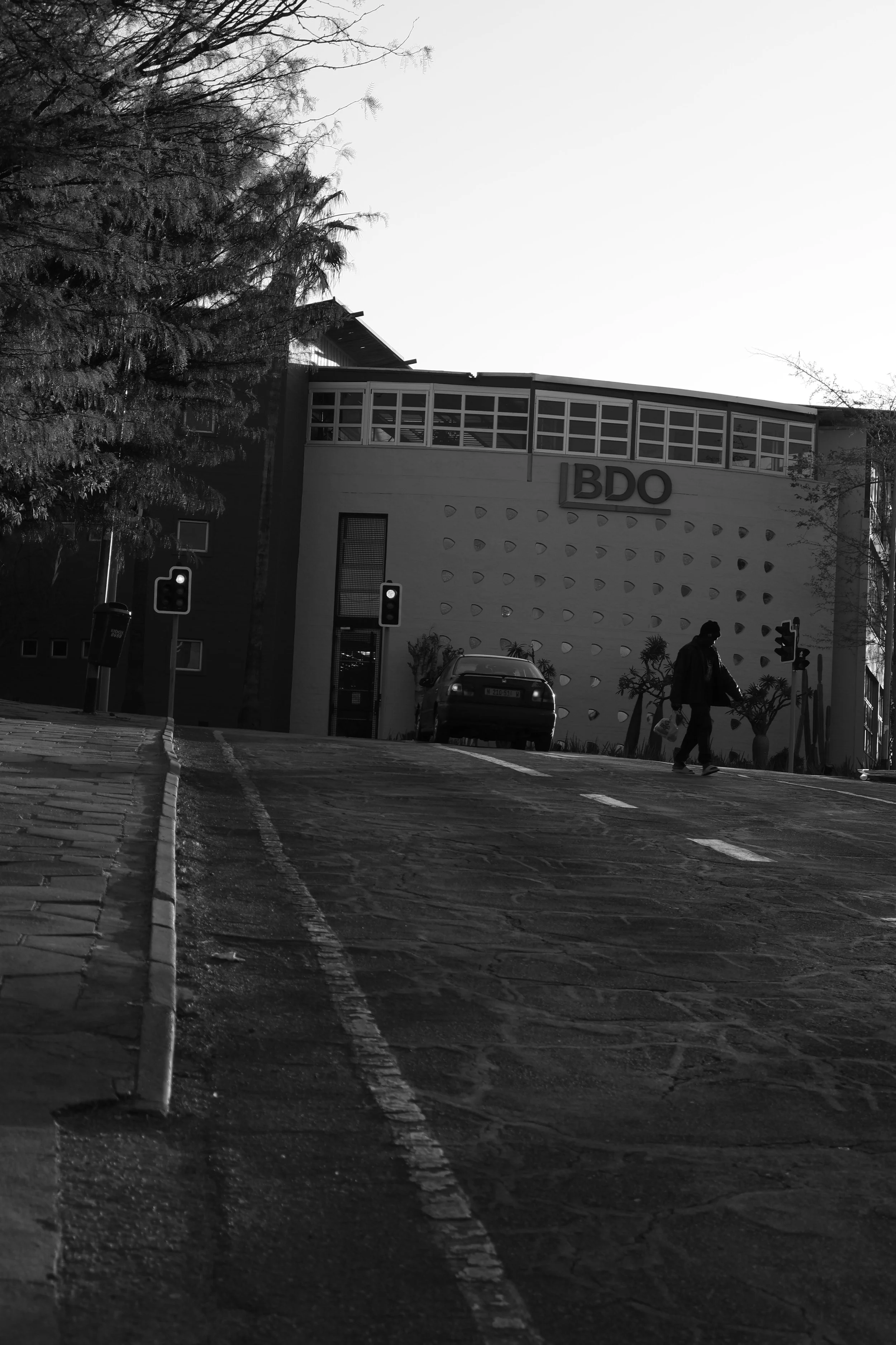 Black and white photograph of a man crossing the street in Windhoek