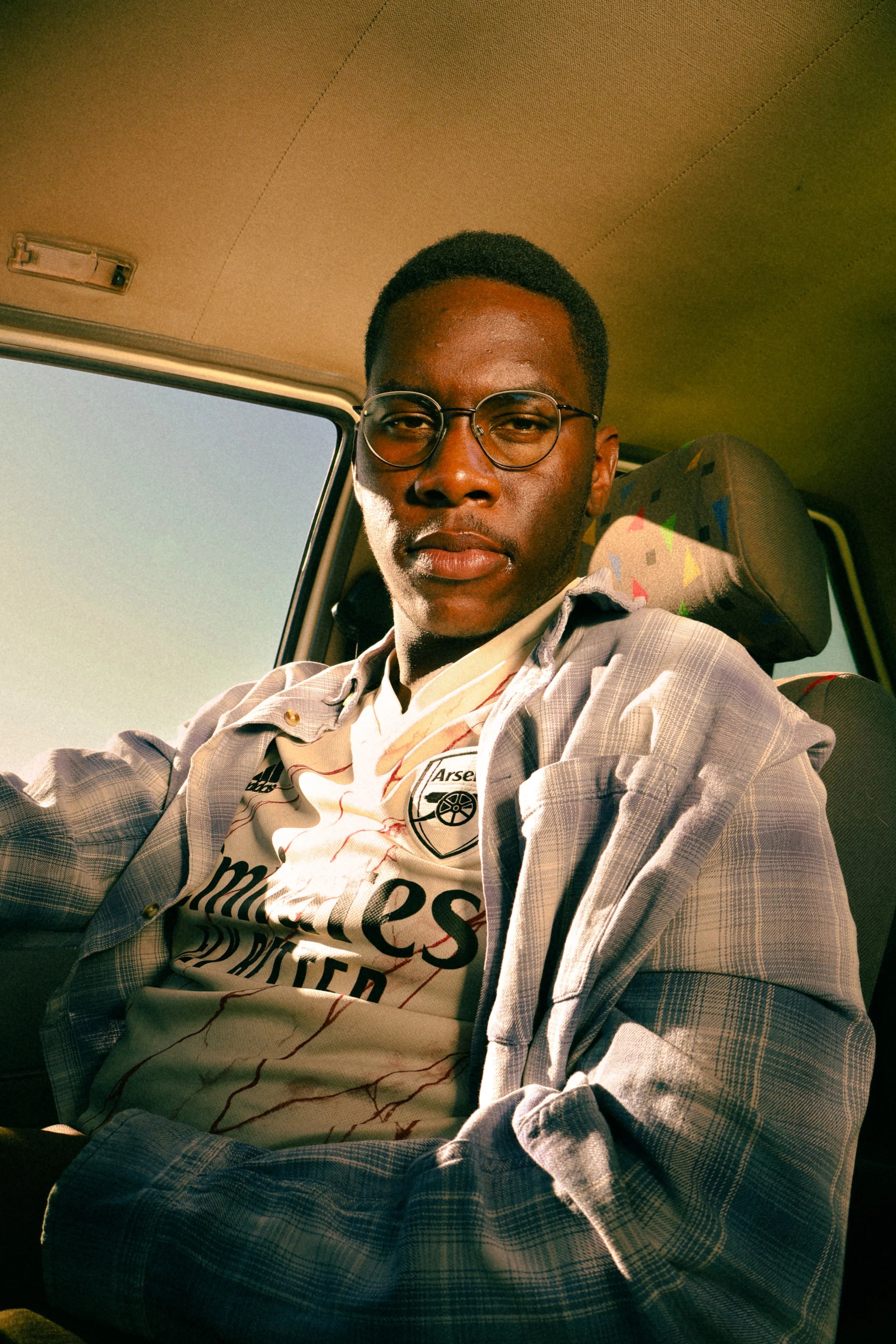 Photograph taken by Kim Kambinda of Eleazar Mwakipesile sitting in his car