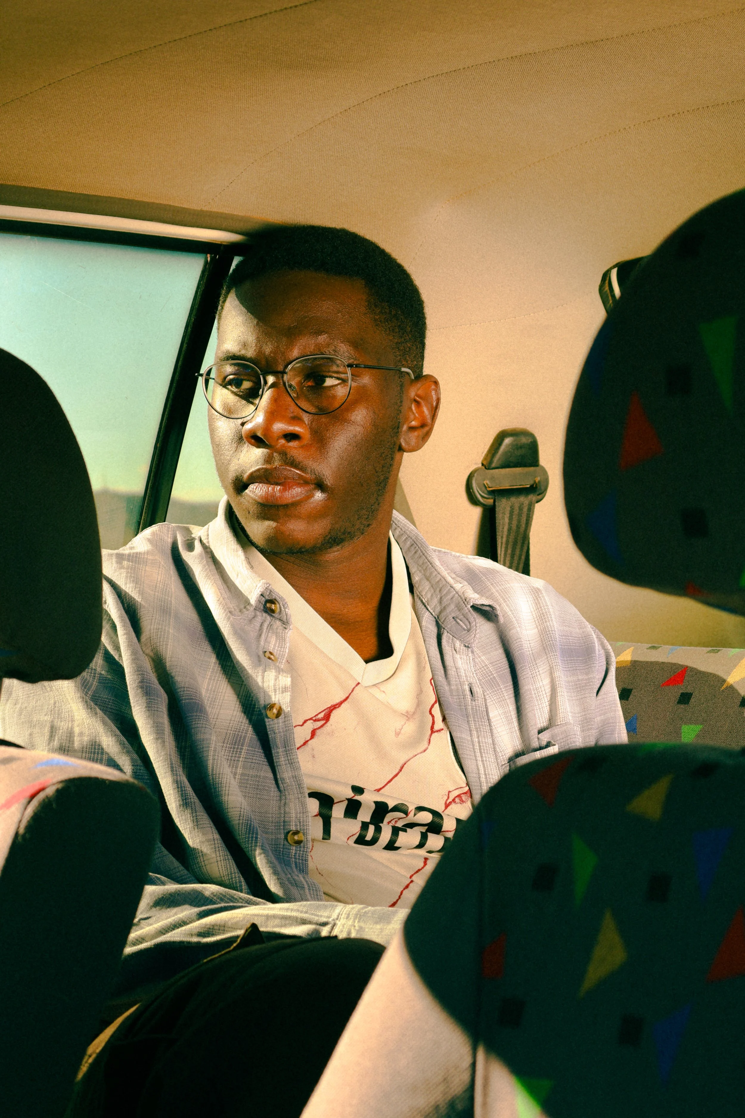 Photograph taken by Kim Kambinda of Eleazar Mwakipesile sitting in his car