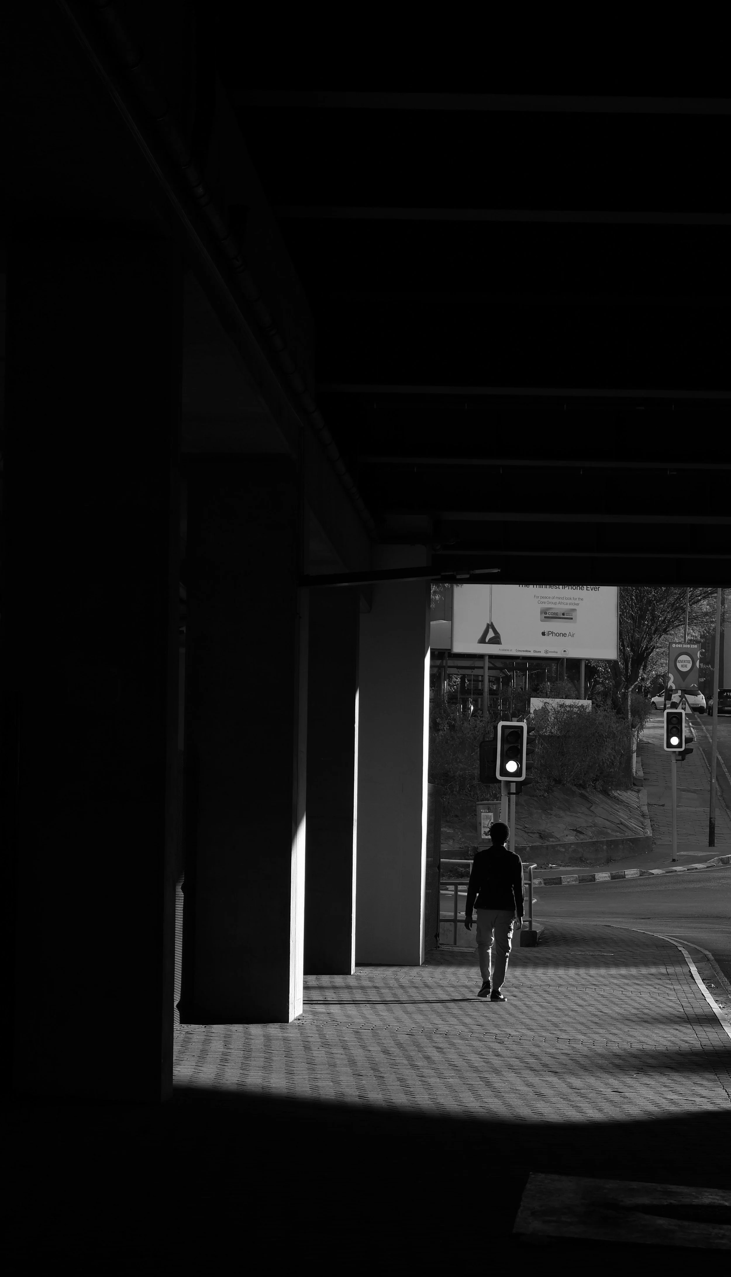 Black and white photograph of a man walking in light