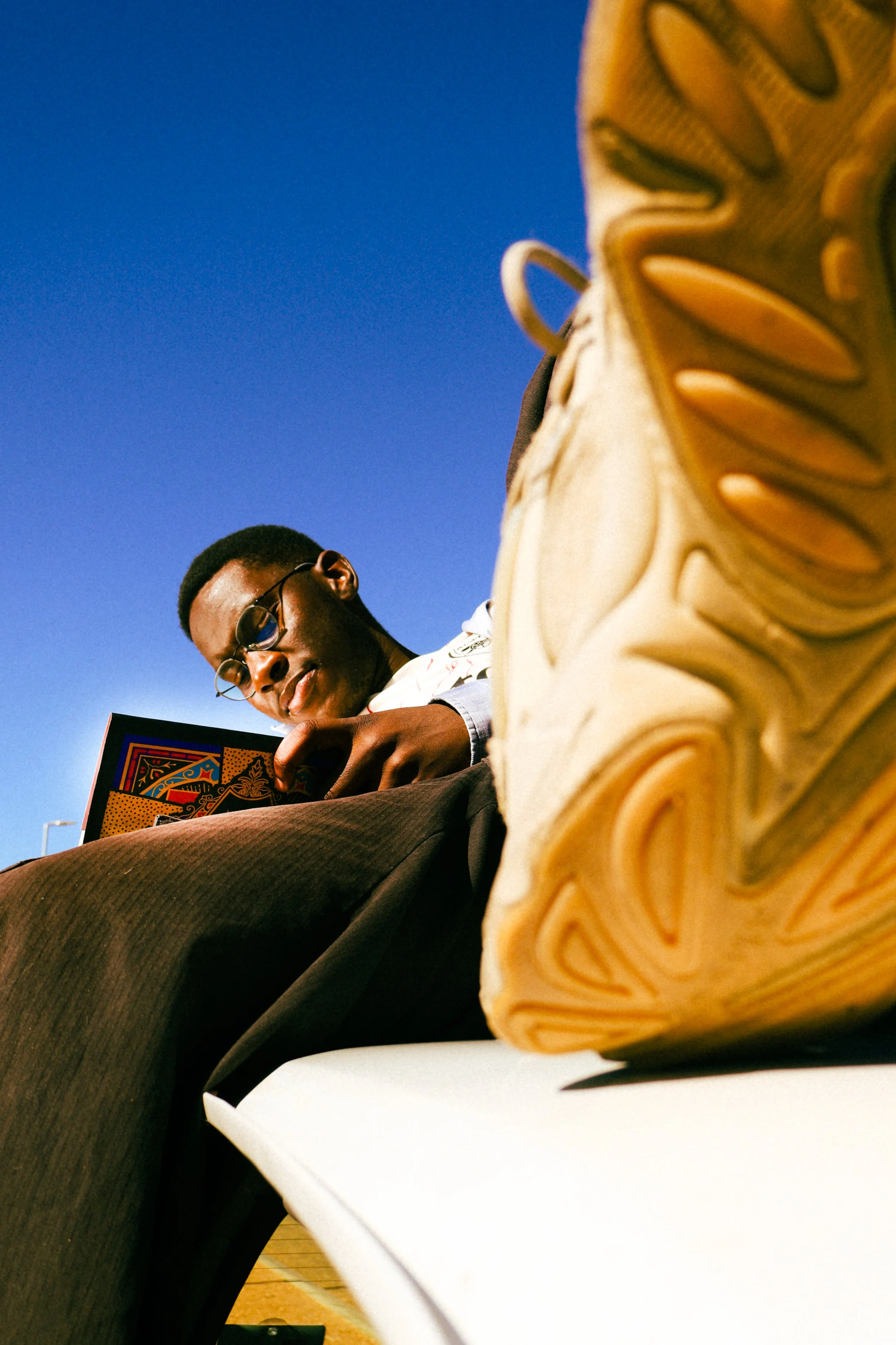 Photograph taken by Kim Kambinda of Eleazar Mwakipesile sitting on top of his car reading a bible