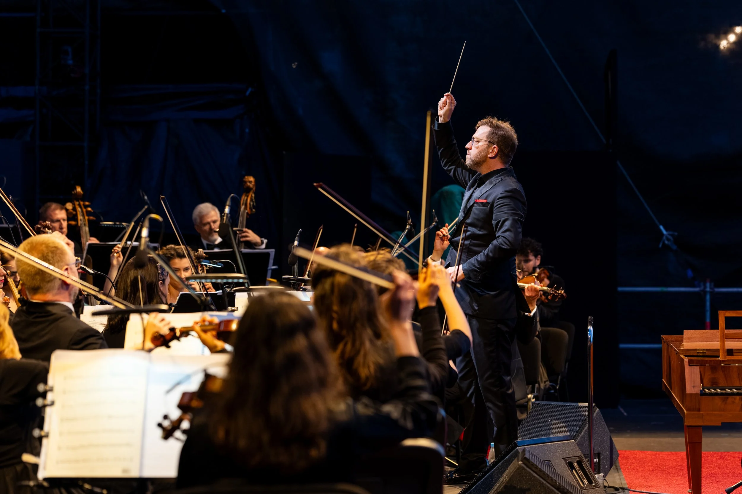 Benjamin Bayl leading an orchestra during a live performance