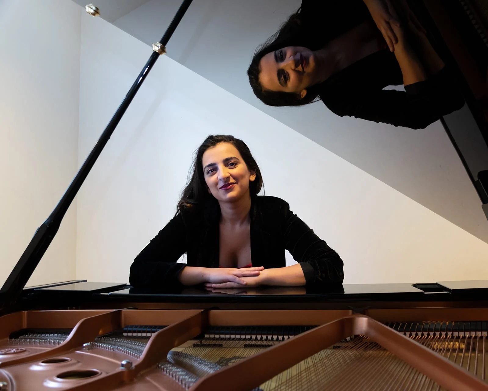 Tinatin Gudadze smiling at a grand piano, hero image for Tinatin's Piano Studio