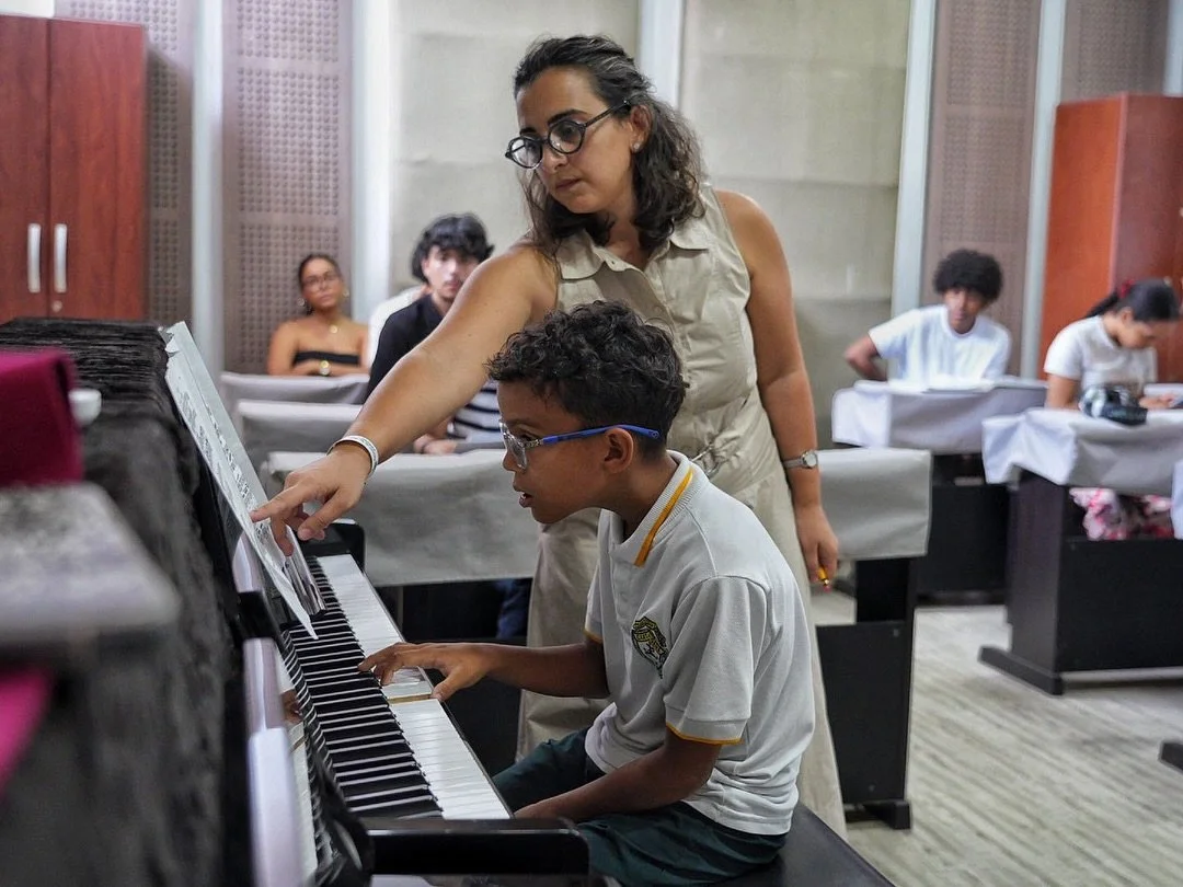 Tinatin Gudadze guiding a young student at the piano during a group lesson