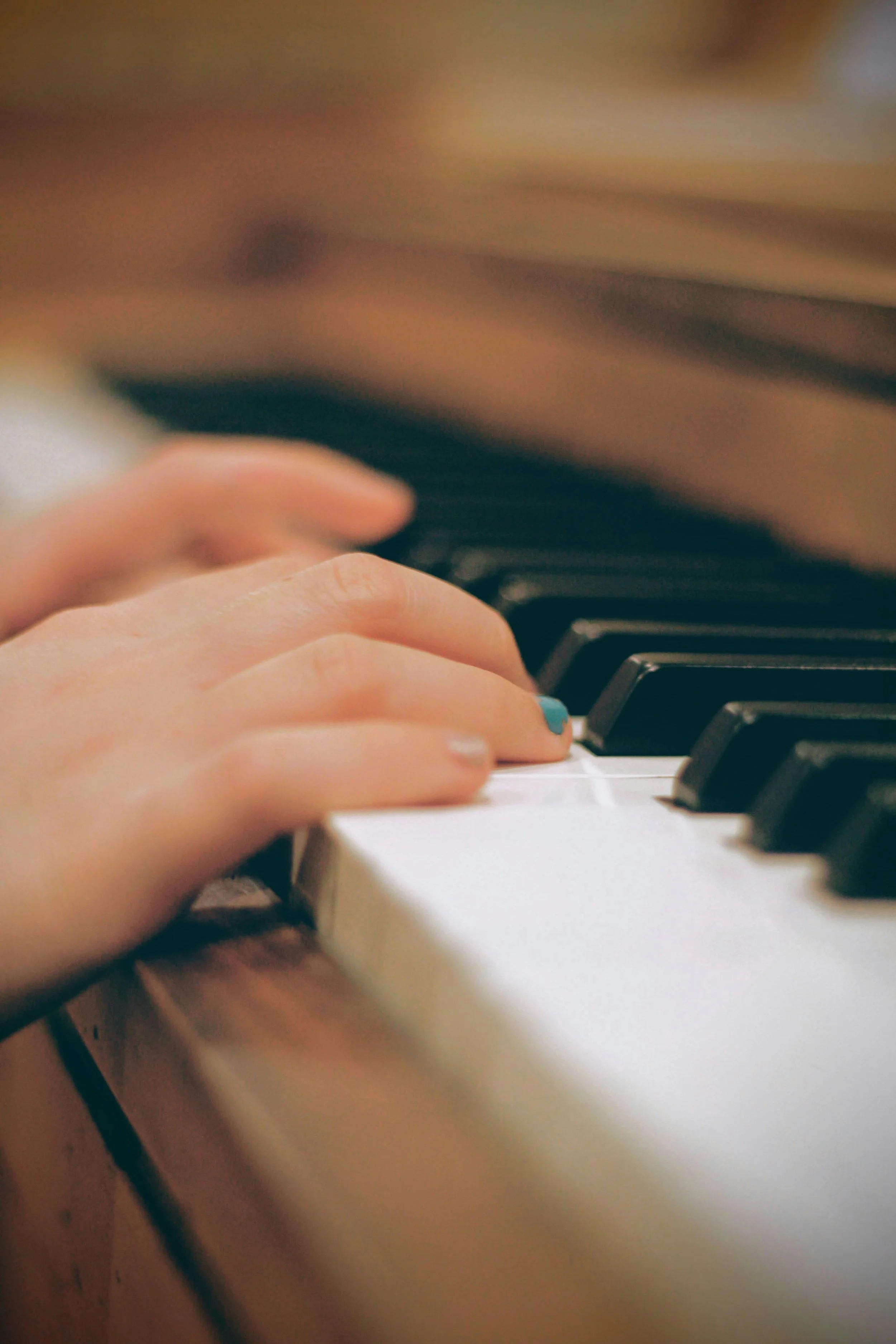 Close-up of a hand playing piano keys