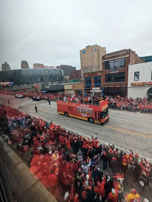 Kansas City Chiefs Super Bowl parade with a red double-decker bus carrying players through a cheering downtown crowd