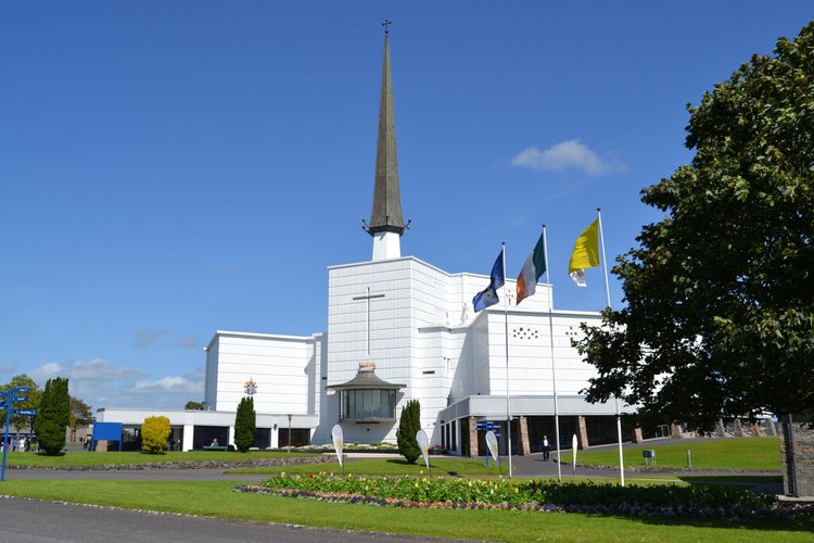 The white exterior and tall spire of Knock Basilica in County Mayo, Ireland.