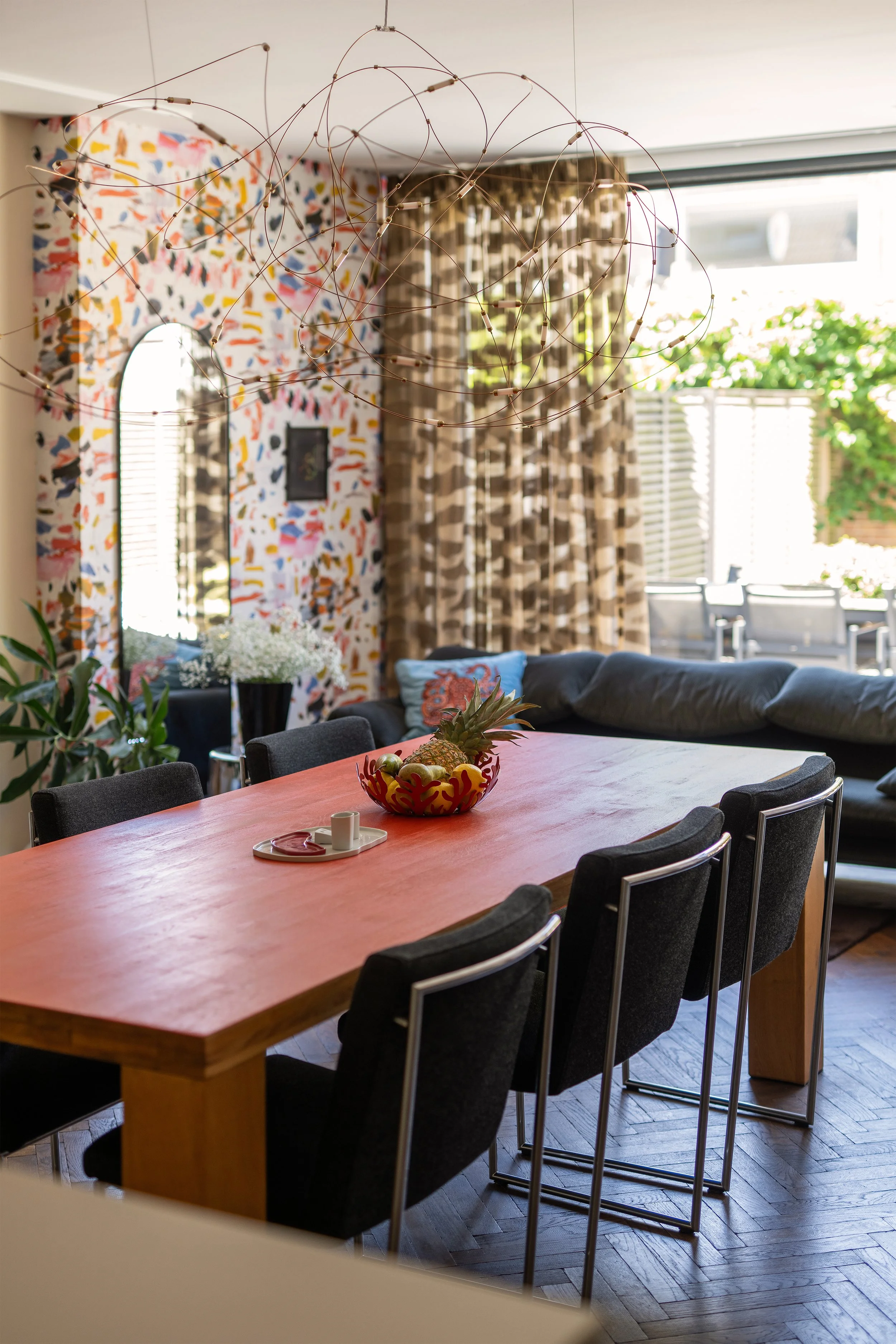 Robuuste eiken eettafel afgewerkt met Linolie Satin Wood Oil in de kleur Beijing, omringd door Harvink Point stoelen in Kvadrat stof onder een Moooi Flock of Light hanglamp.