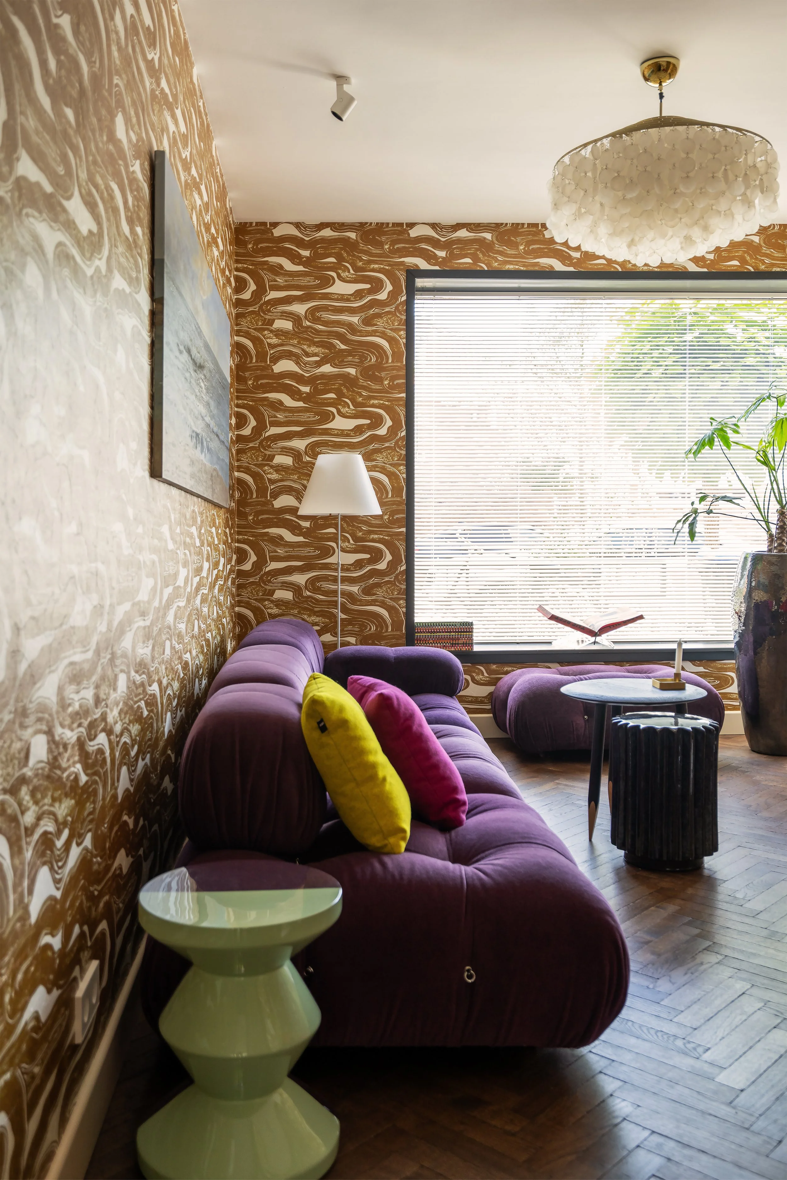 Gezellige, knusse televisiekamer met een paarse B&B Italia Camaleonda sofa van Mario Bellini en Pierre Frey Nuages behang met wolkenpatroon.