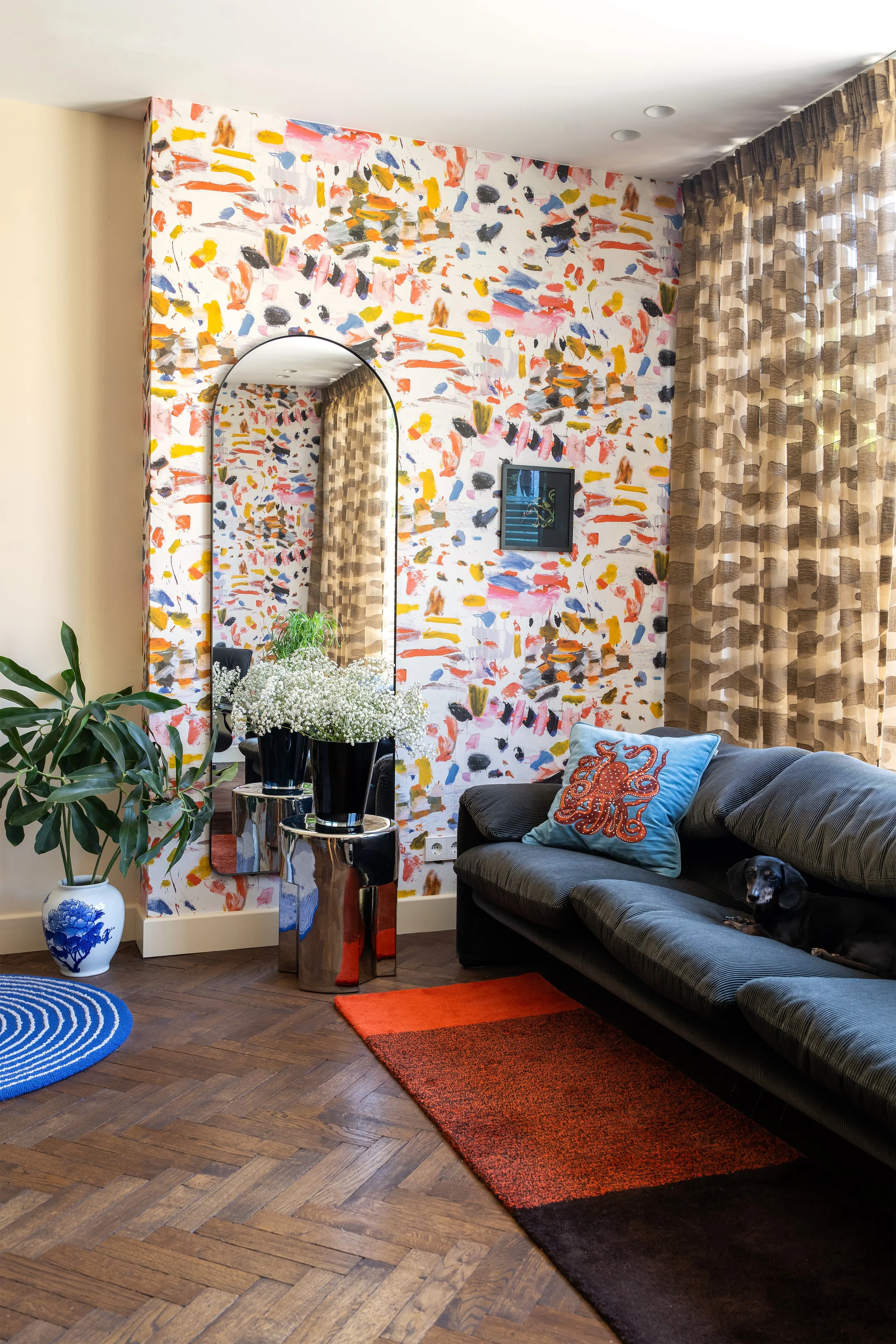 Uitbouw in een moderne woonkamer met een iconische Cassina Maralunga sofa, Pierre Frey Arty behang en een Suite702 vloerkleed van Lex Pott.