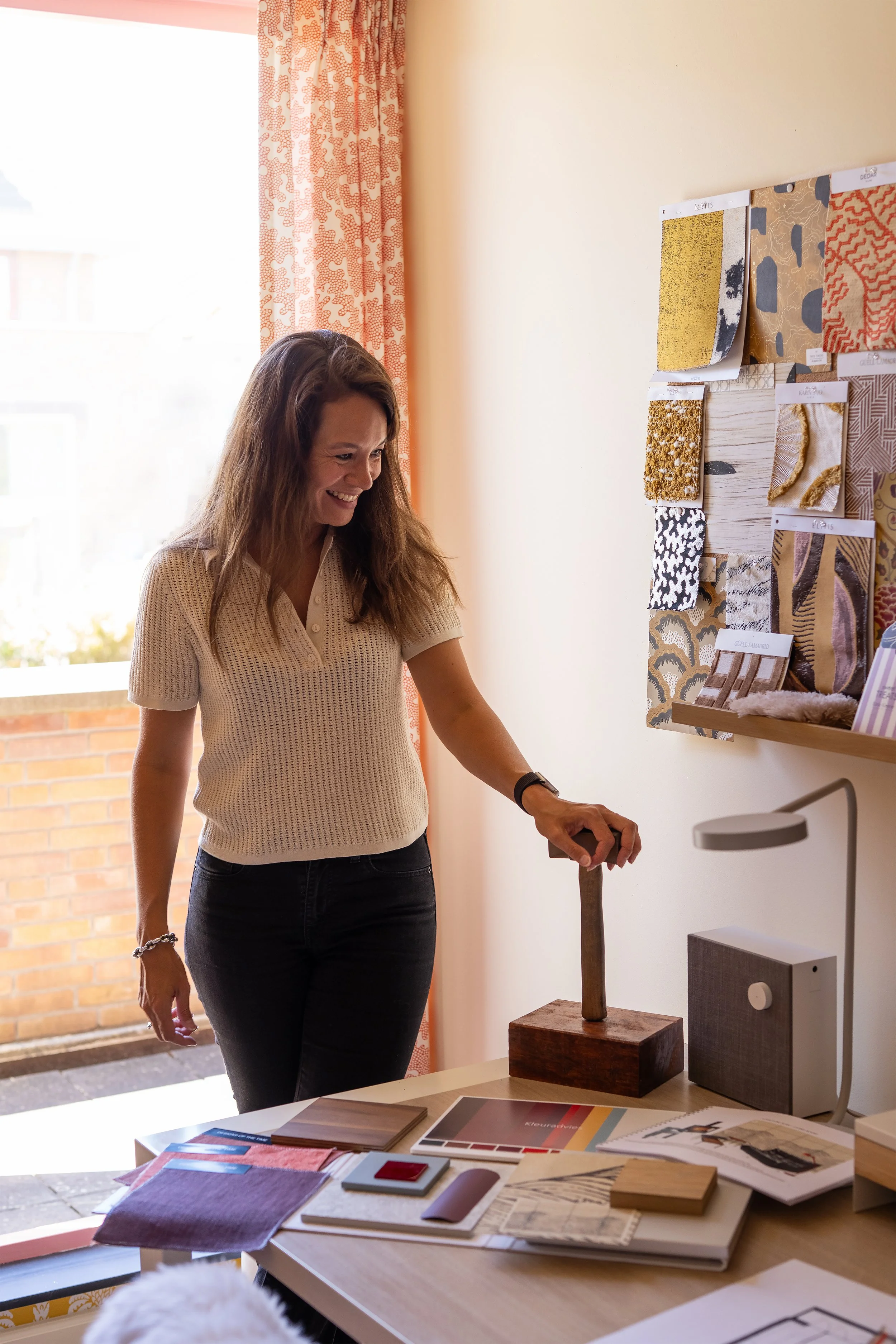 Isabelle, interieurontwerper van Belle & Bold, aan het werk met een kleur- en materiaalmoodboard in haar studio