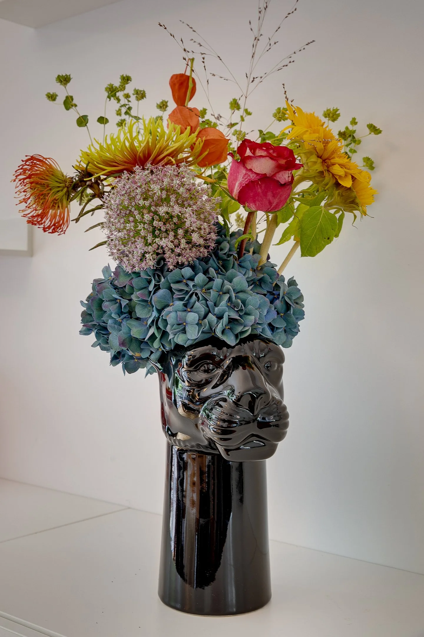 Interieurstyling detail met boeket in zwarte panter vaas, onderdeel van luxe woonkamerinrichting door Belle & Bold Interior Design. 