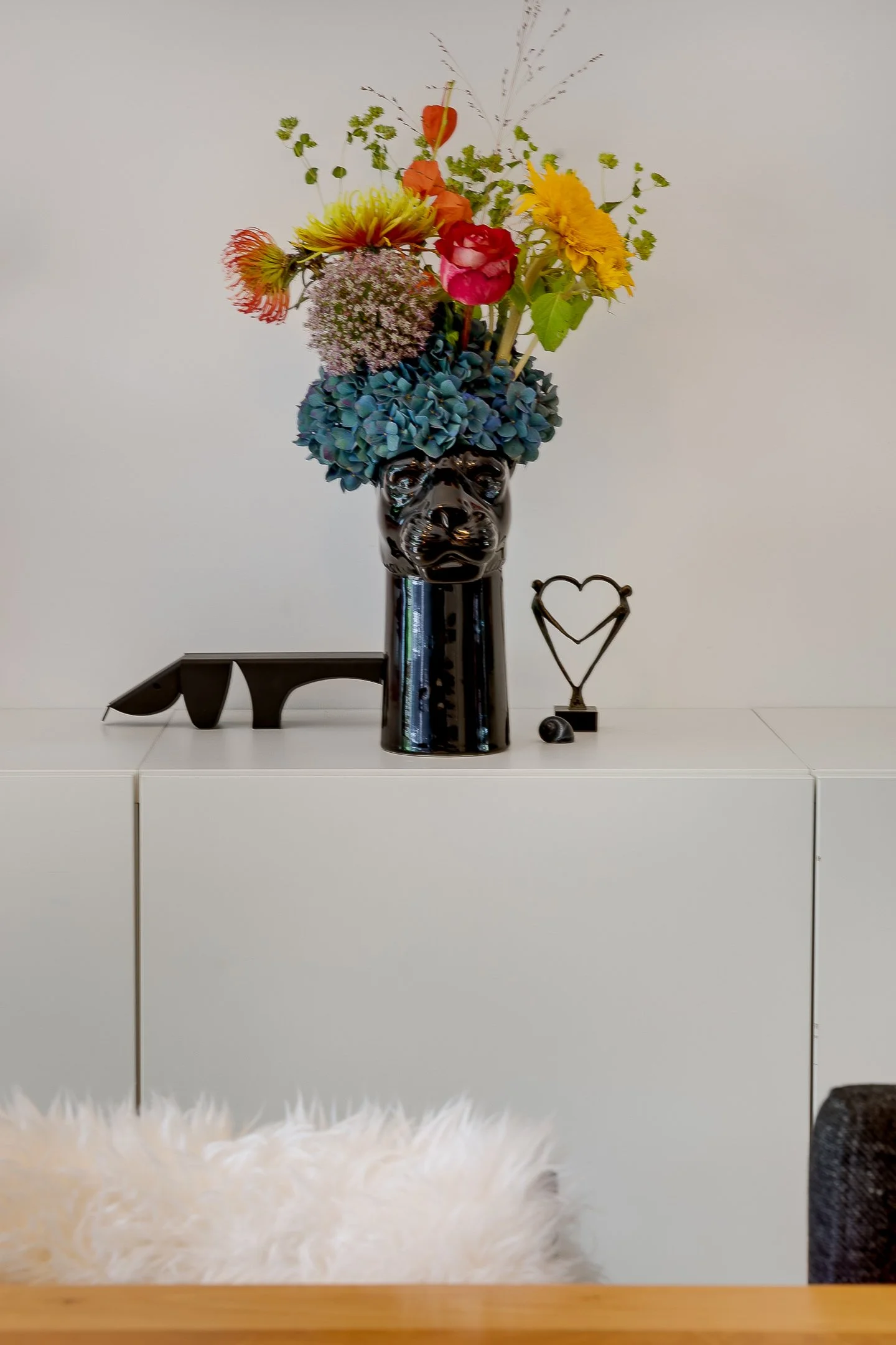 Kleurrijk bloemboeket in een panter vaas, een gedurfd statement in een luxe interieur in een jaren '30 herenhuis in Den Haag.