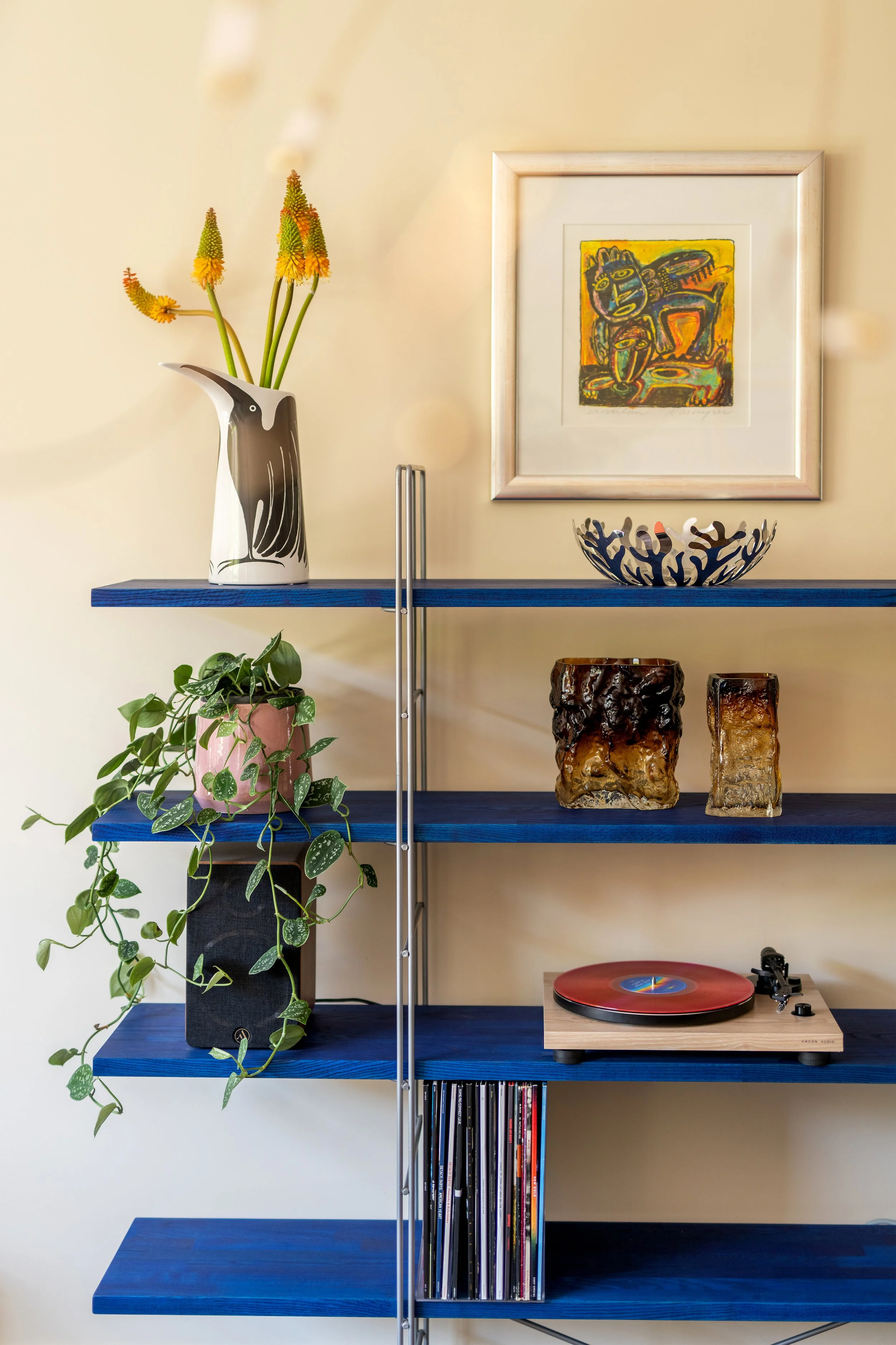 Vintage IKEA Enetri wandkast ontworpen door Niels Gammelgaard gehackt met blauwe houten planken gestyled met een platenspeler, LP's en decoratieve design objecten.
