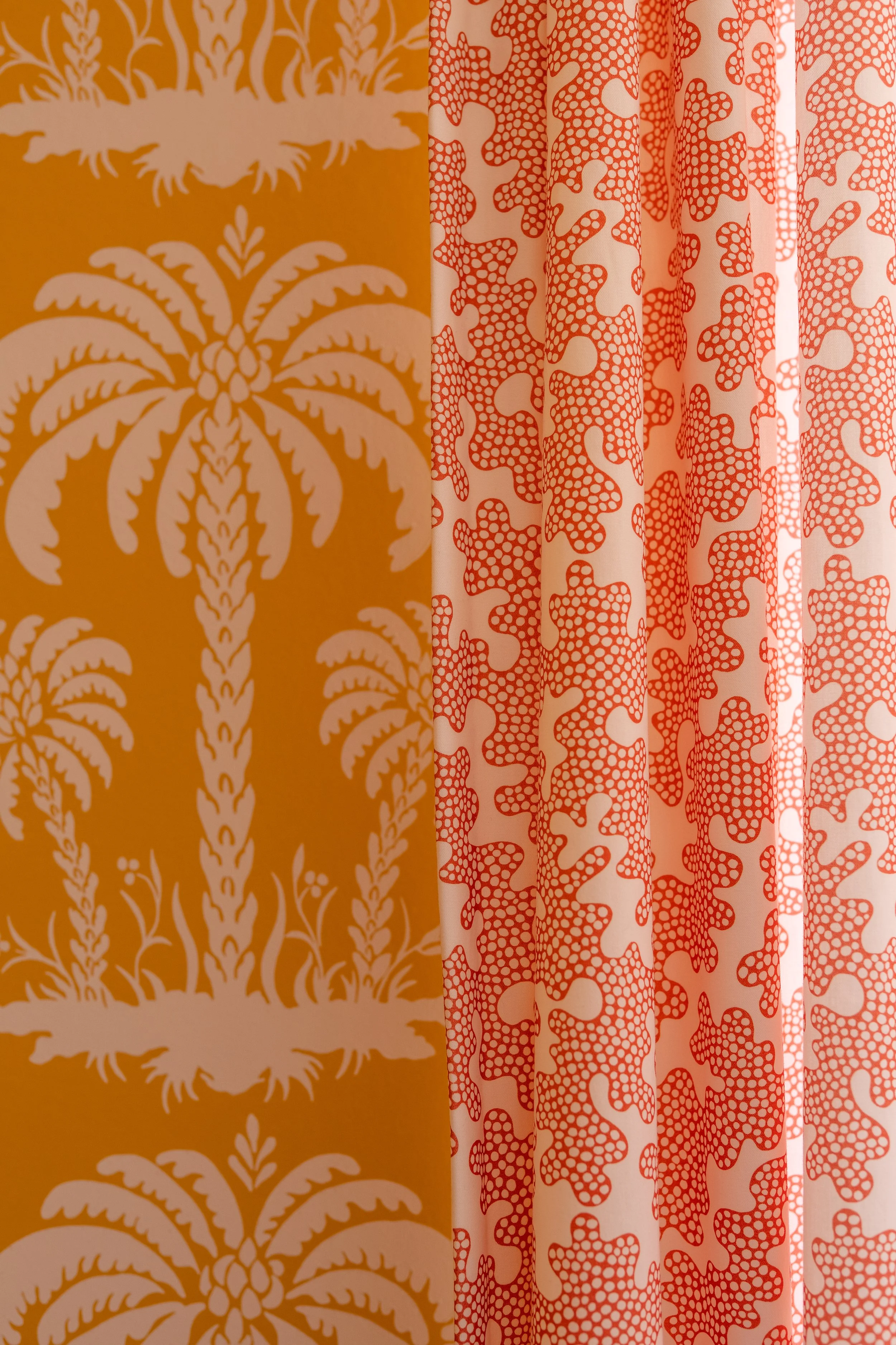 Strand vibe in de studio van Belle & Bold Interior Design (Den Haag) met geel palmbomenbehang van Thibaut en gordijn met koraalmotief van Harlequin. 
