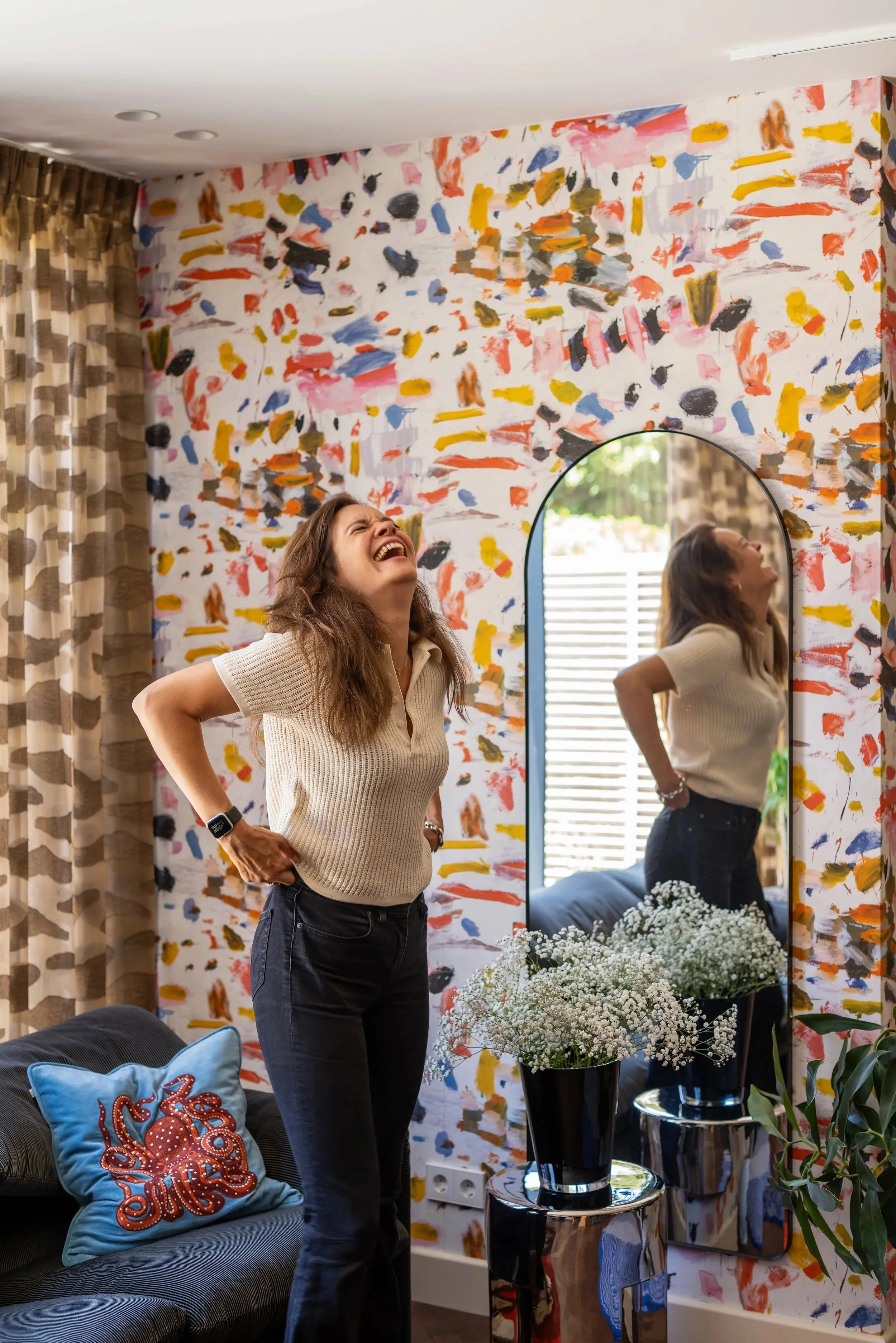 Isabelle, interieurontwerper van Belle & Bold, voor kleurrijk Pierre Frey Arty behang met een Chhatwal & Jonsson octopuskussen bij haar thuis in Den Haag