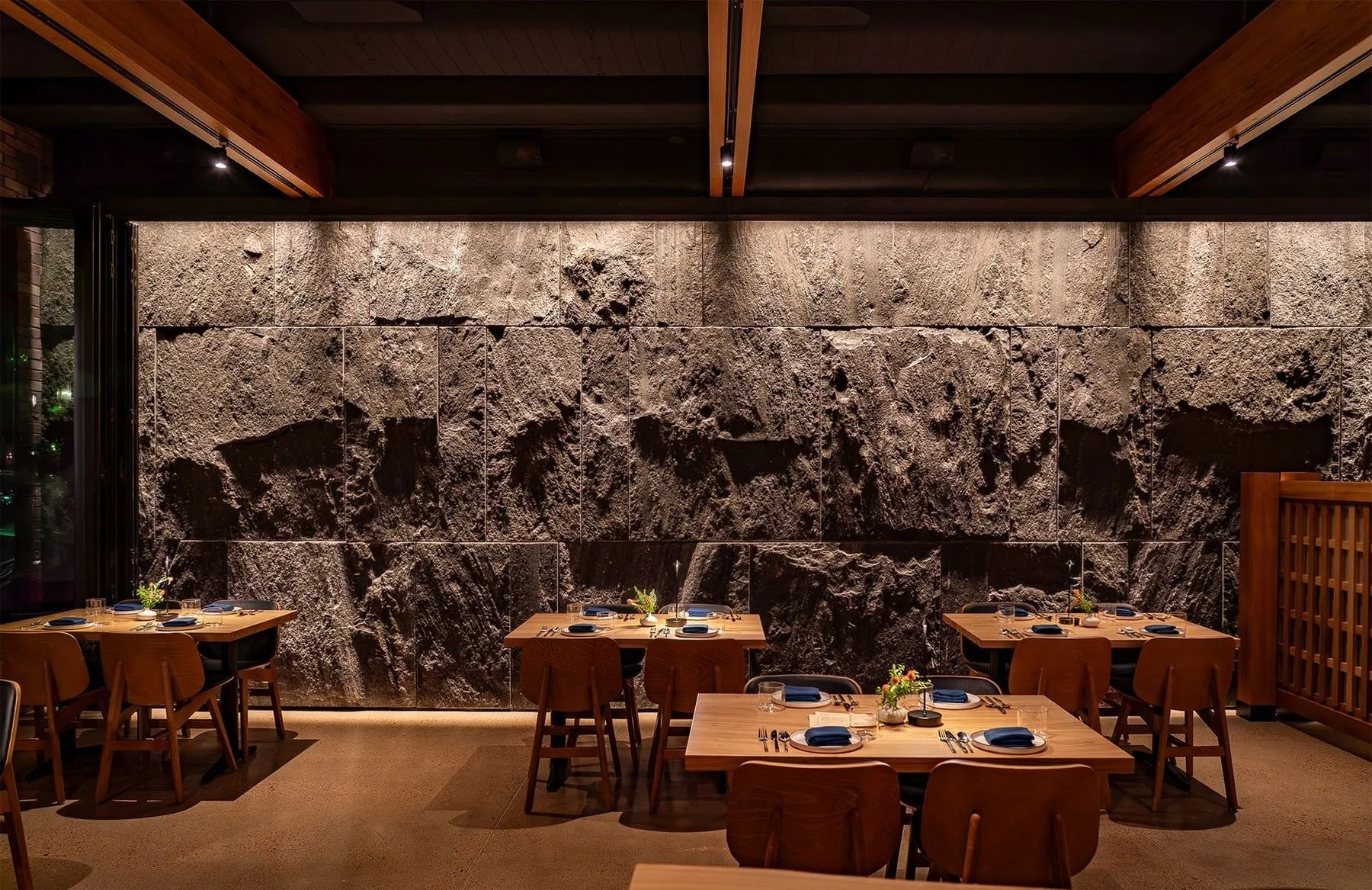 Margot's dining room, wrapped in warm wood beneath the stone shell.