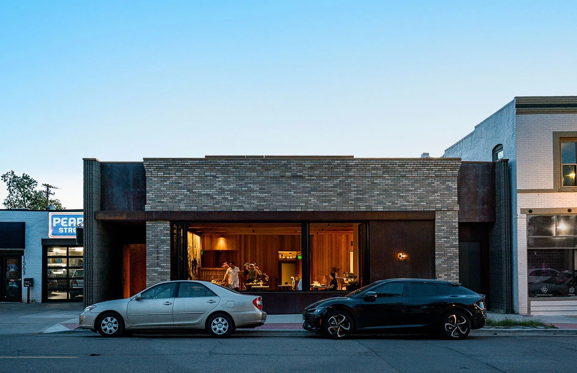 The South Pearl Street facade at dusk — a rugged outer shell of concrete, masonry, and steel.