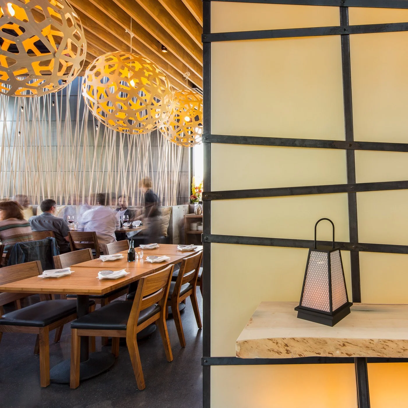 Dining along the yellow lattice wall, a paper lantern at each table.