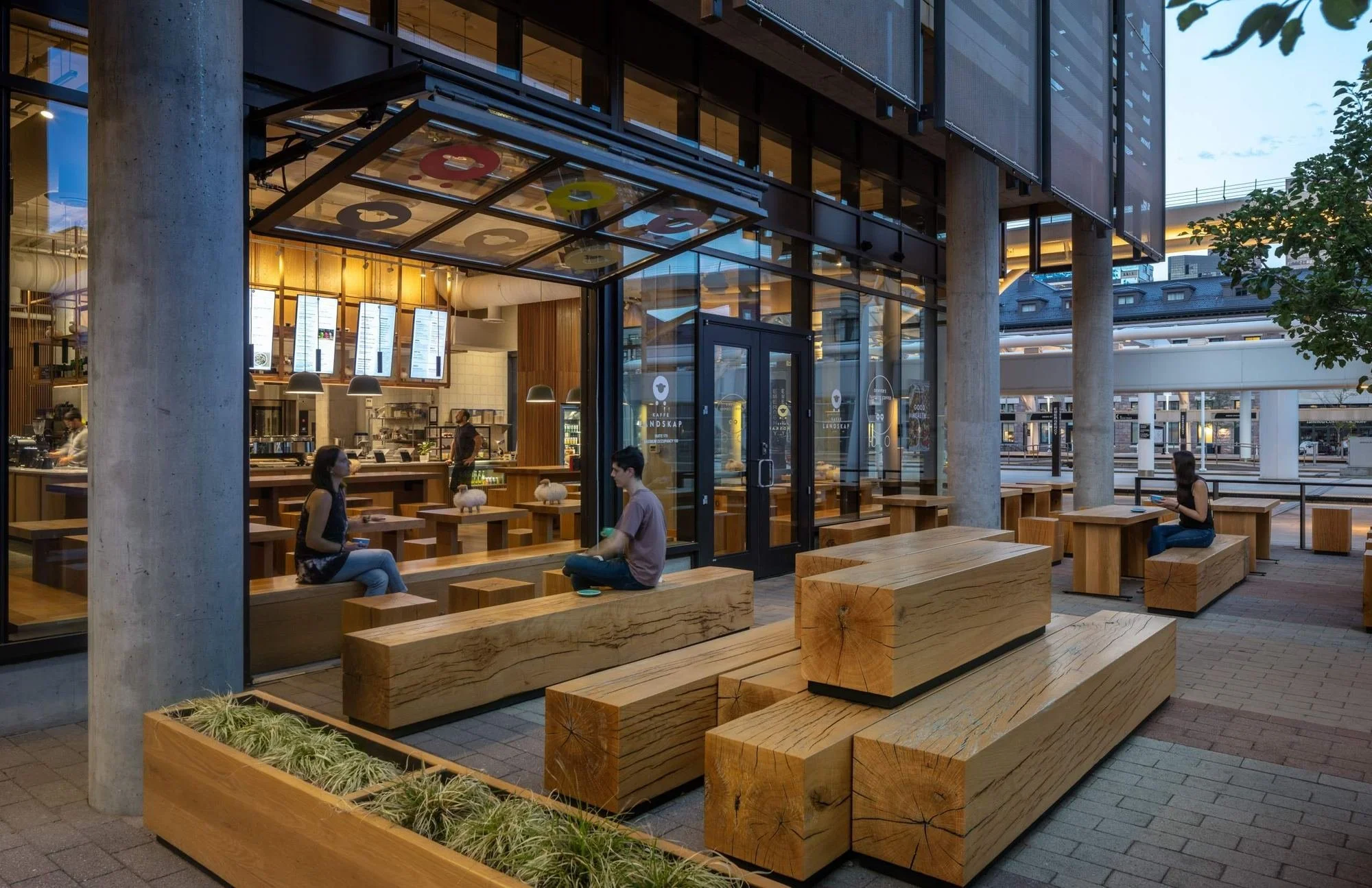 Large wooden slabs are stacked like tree logs to form the patio seating.