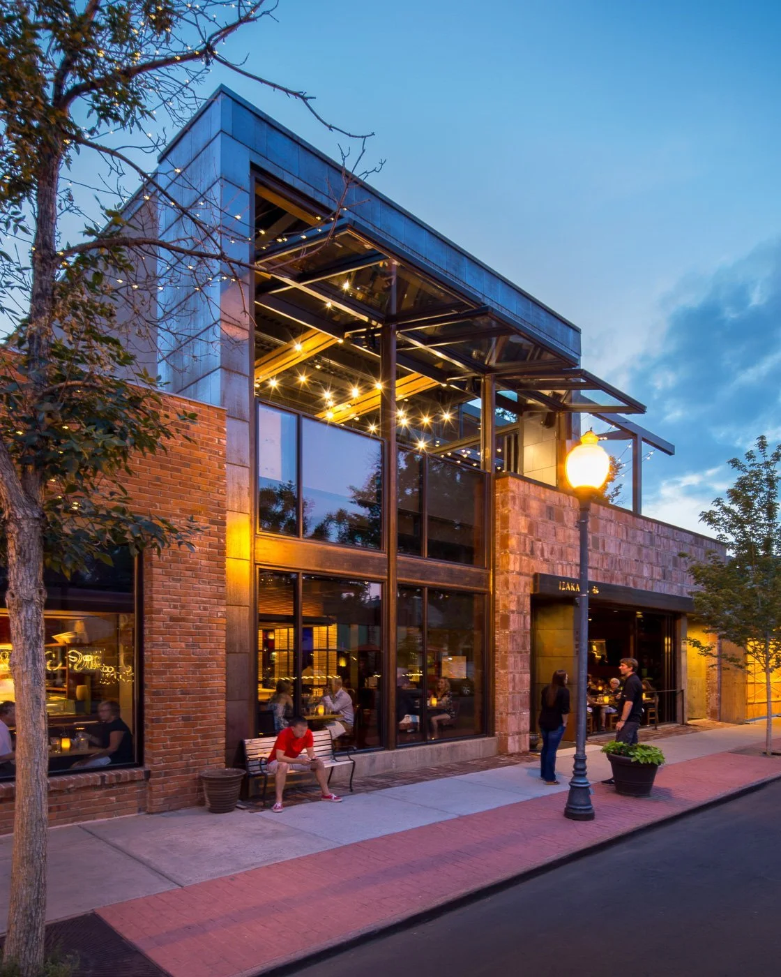 The corner entry at dusk, seen from the sidewalk.