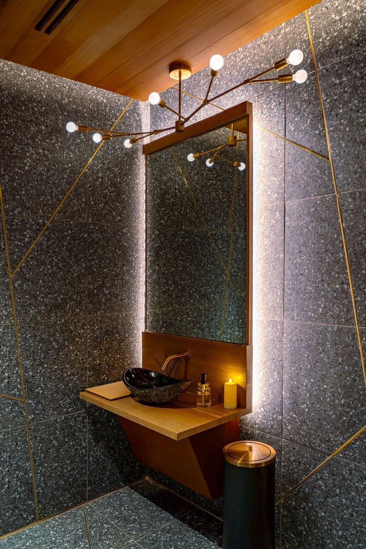 The kintsugi restroom — gold seams across a cracked stone surface.