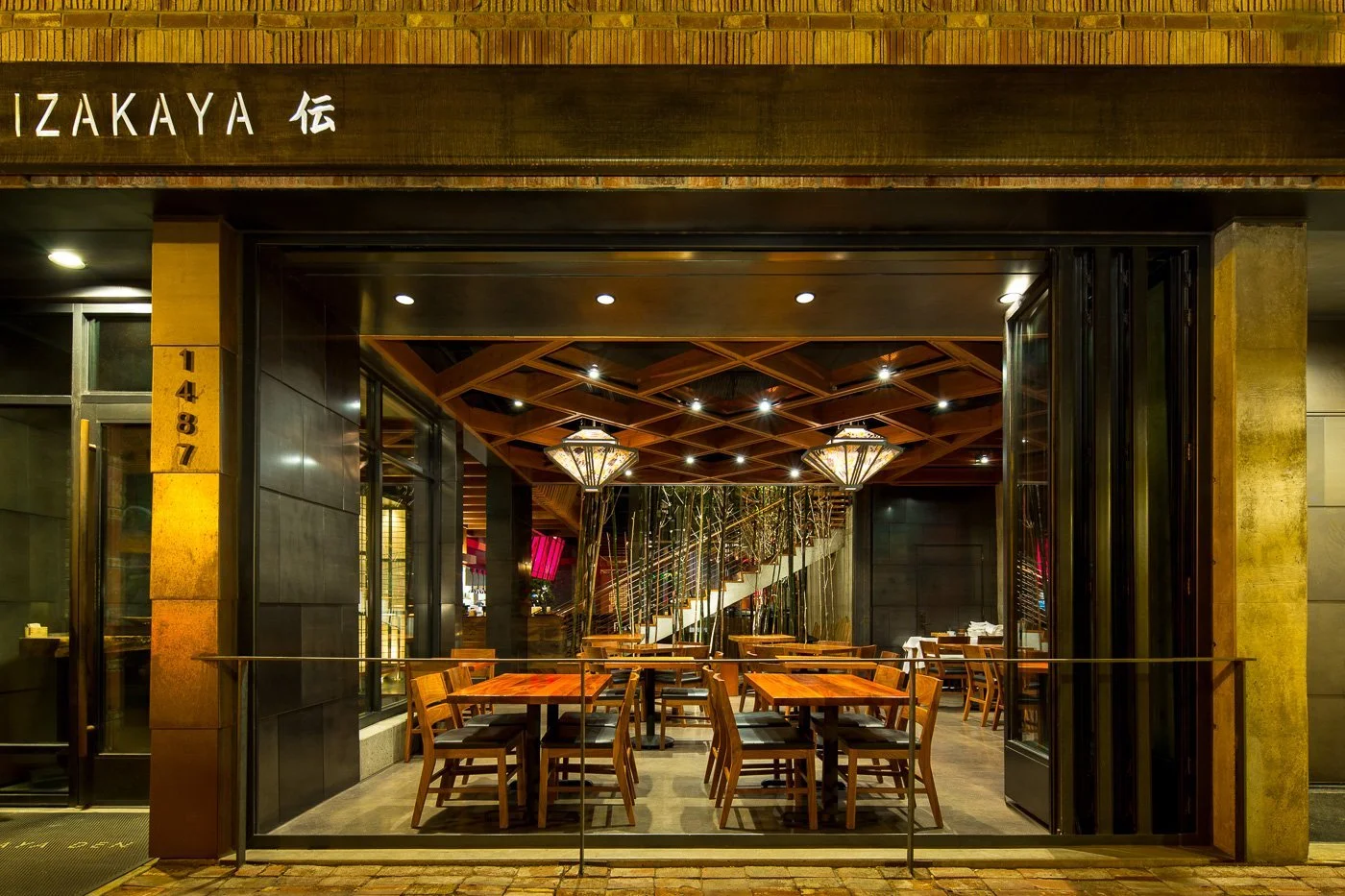 Ten-foot hinged windows pivot out to the sidewalk, opening the ground floor to the street.