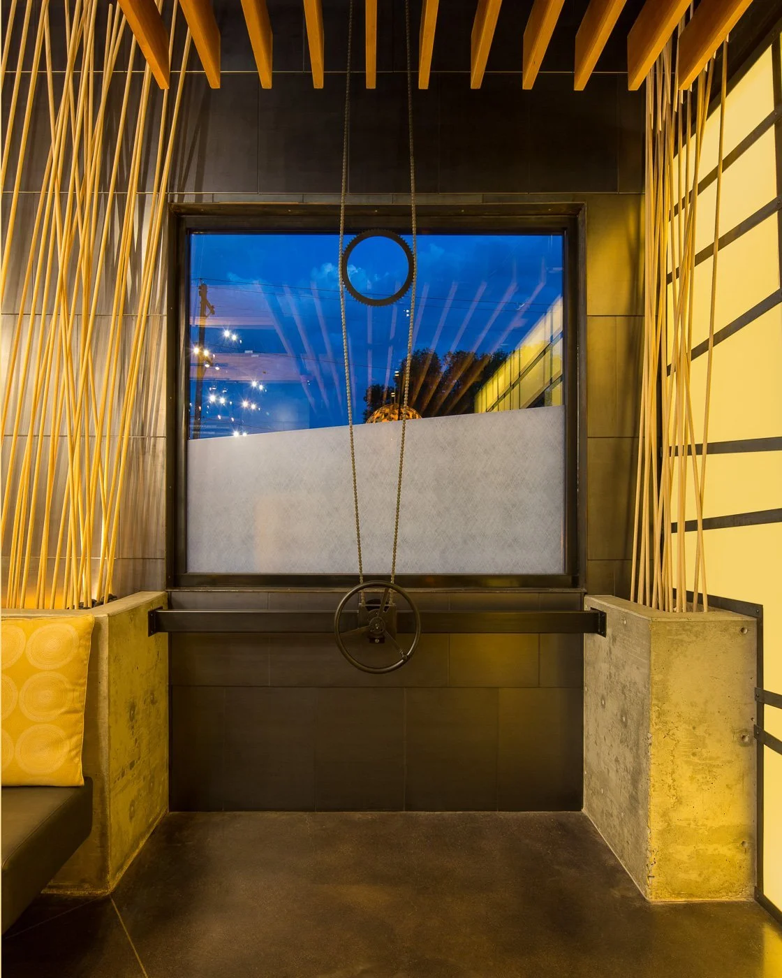 A slatted wood ceiling and bamboo-panel walls line the passage toward the street.
