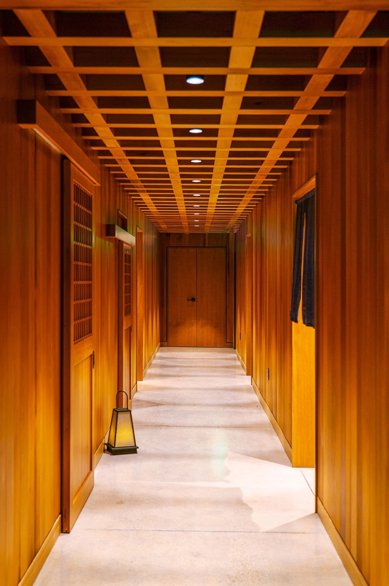 The canopy hallway — a wood lattice overhead marks the passage between rooms.