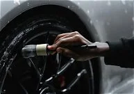 Person filling a car's tire with air using a pump
