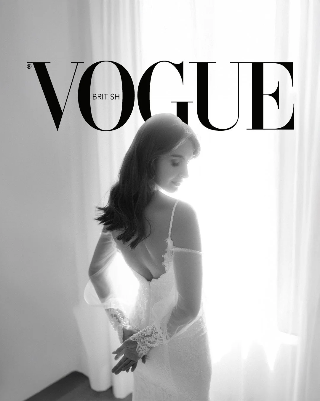 Black and white Vogue British magazine cover featuring a woman in a wedding dress, standing by a window with curtains.