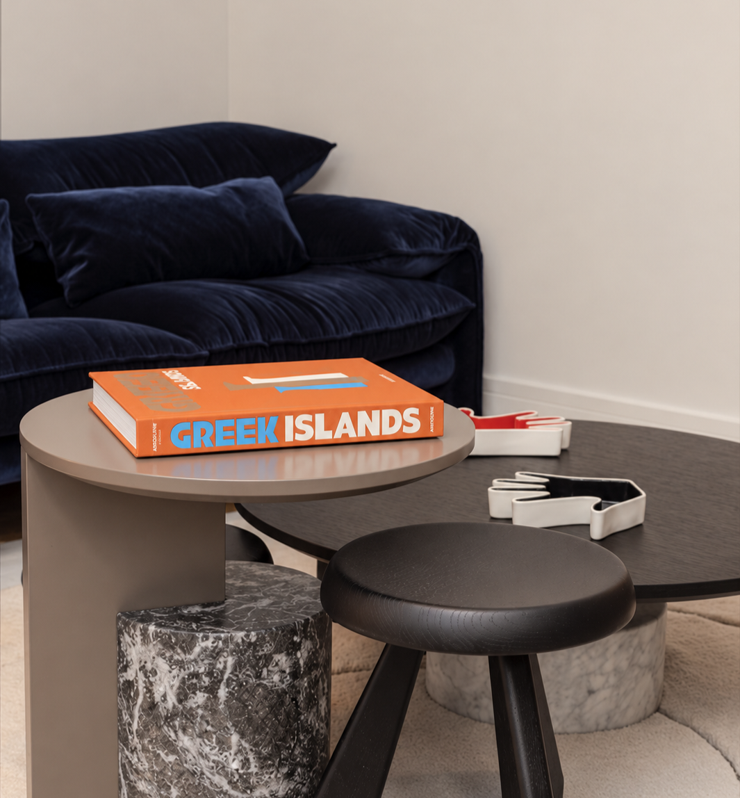 Interior detail in Salamanca, Madrid, featuring layered coffee tables, a deep blue sofa and carefully curated decorative accents.