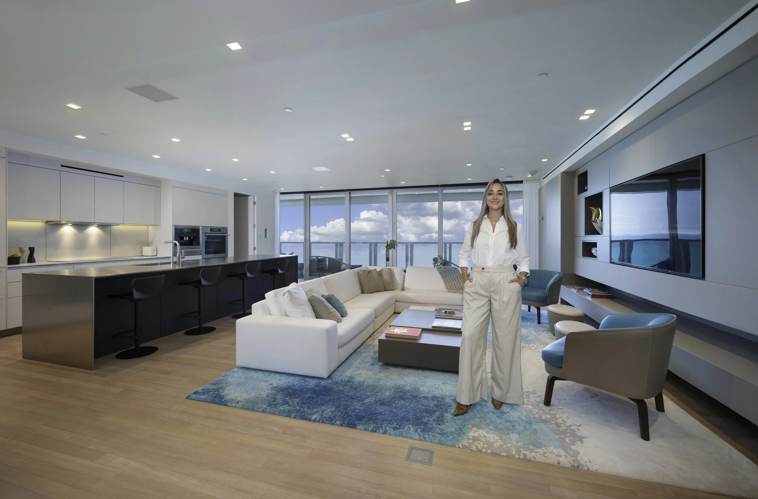 Light-filled living room where ocean-inspired blue tones are carried into the interior, complementing a warm neutral palette and expansive views.