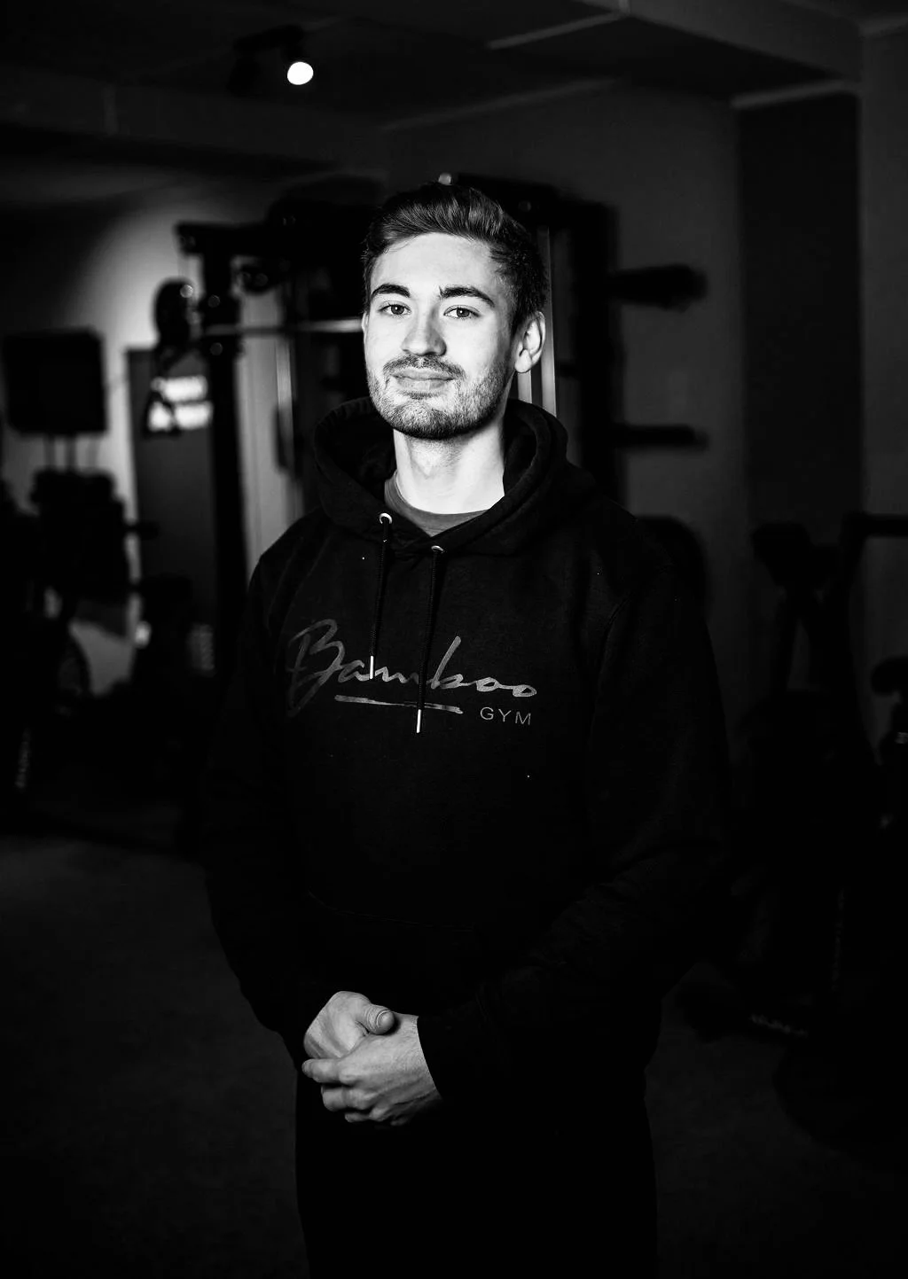 Portret van een jonge man in een sportschool, zwart-wit.