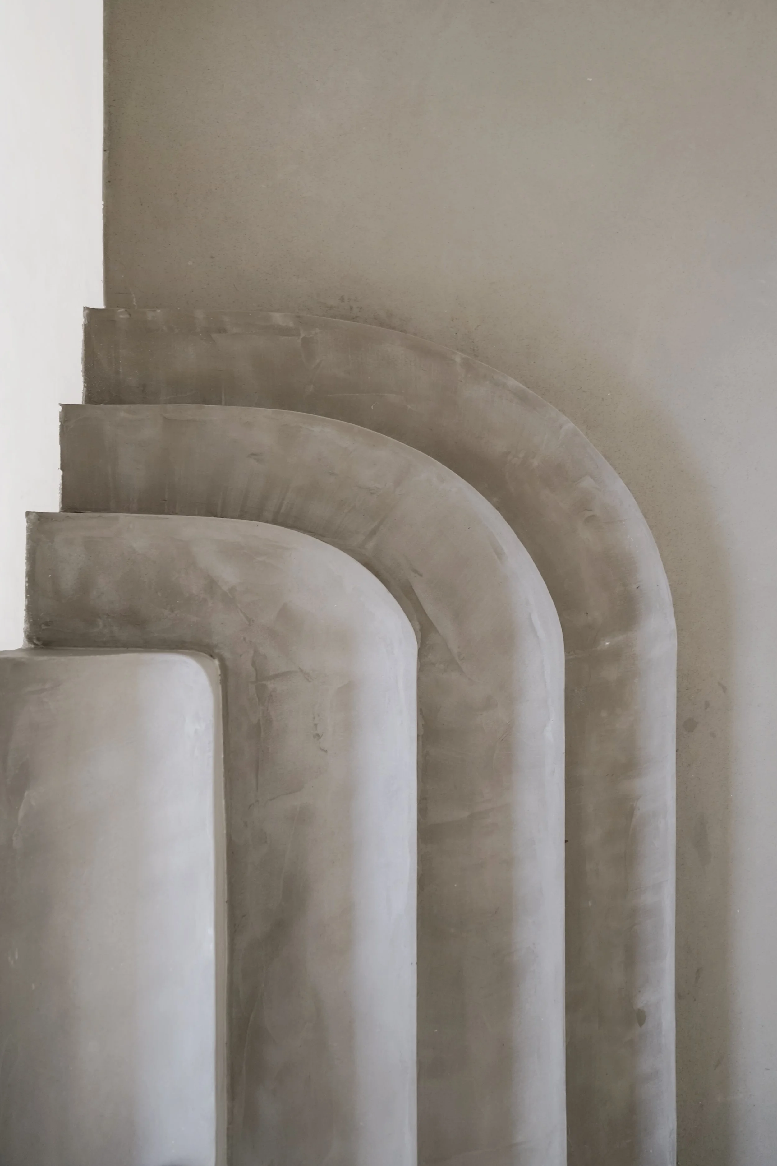 Escaleras de cemento con forma curva, en una construcción en progreso, vista de lado.