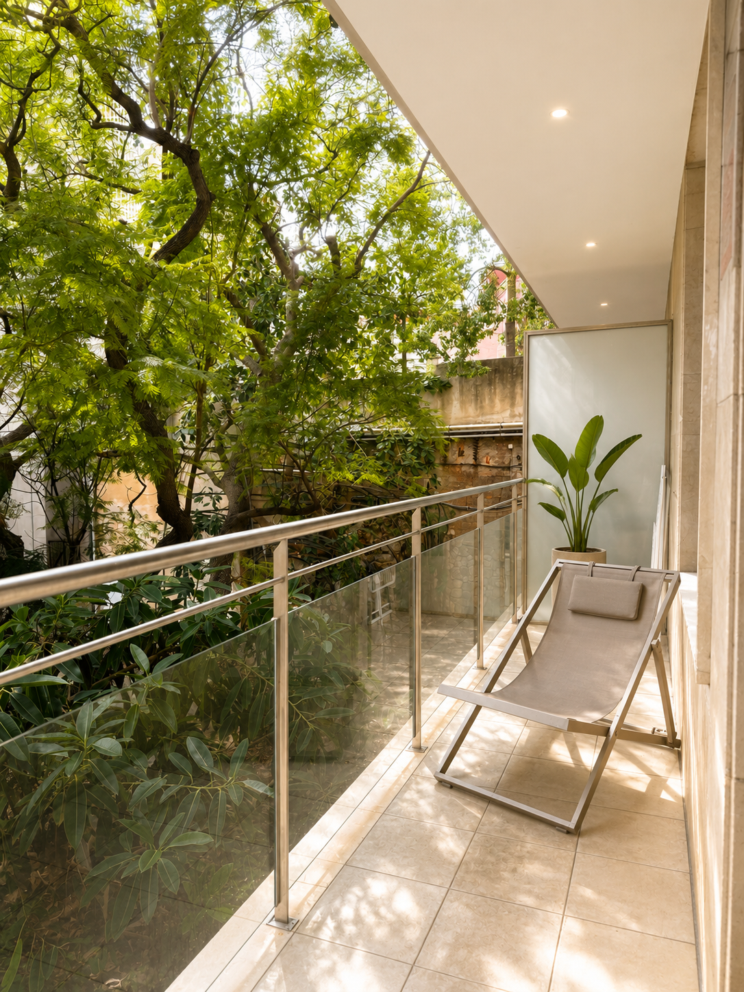 Balcón con silla de descanso, planta en maceta y vista de árboles y vegetación exterior