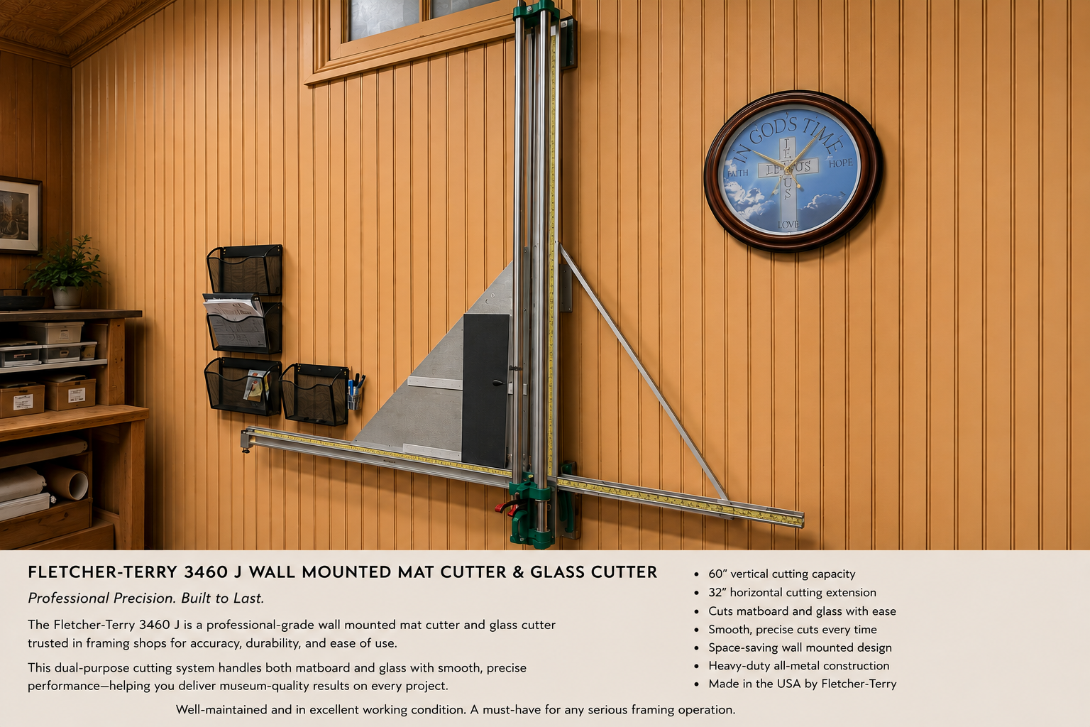 Image of a Fletcher-Terry 3460 J wall-mounted mat cutter and glass cutter in a workshop with wood-paneled walls, a clock, and office supplies.