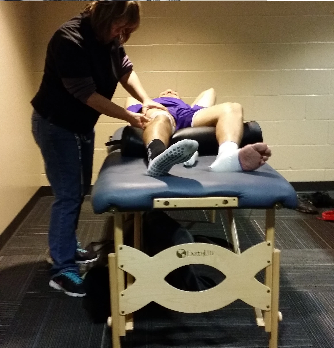 Emma giving a massage to a person in a purple shirt