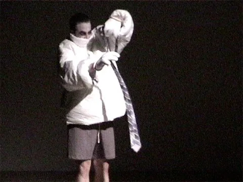 A man-moth enters with his own light. A boy struggles to tie a tie. 
