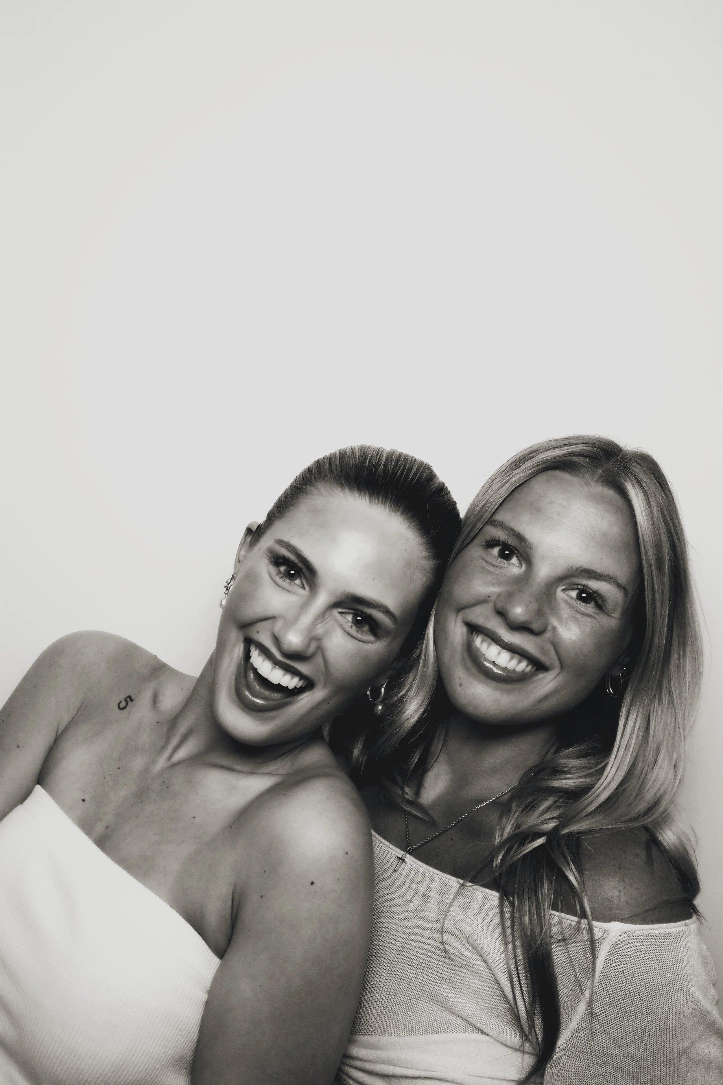 Two guests laughing together in a printed photo strip from 801 Booth's enclosed photo booth