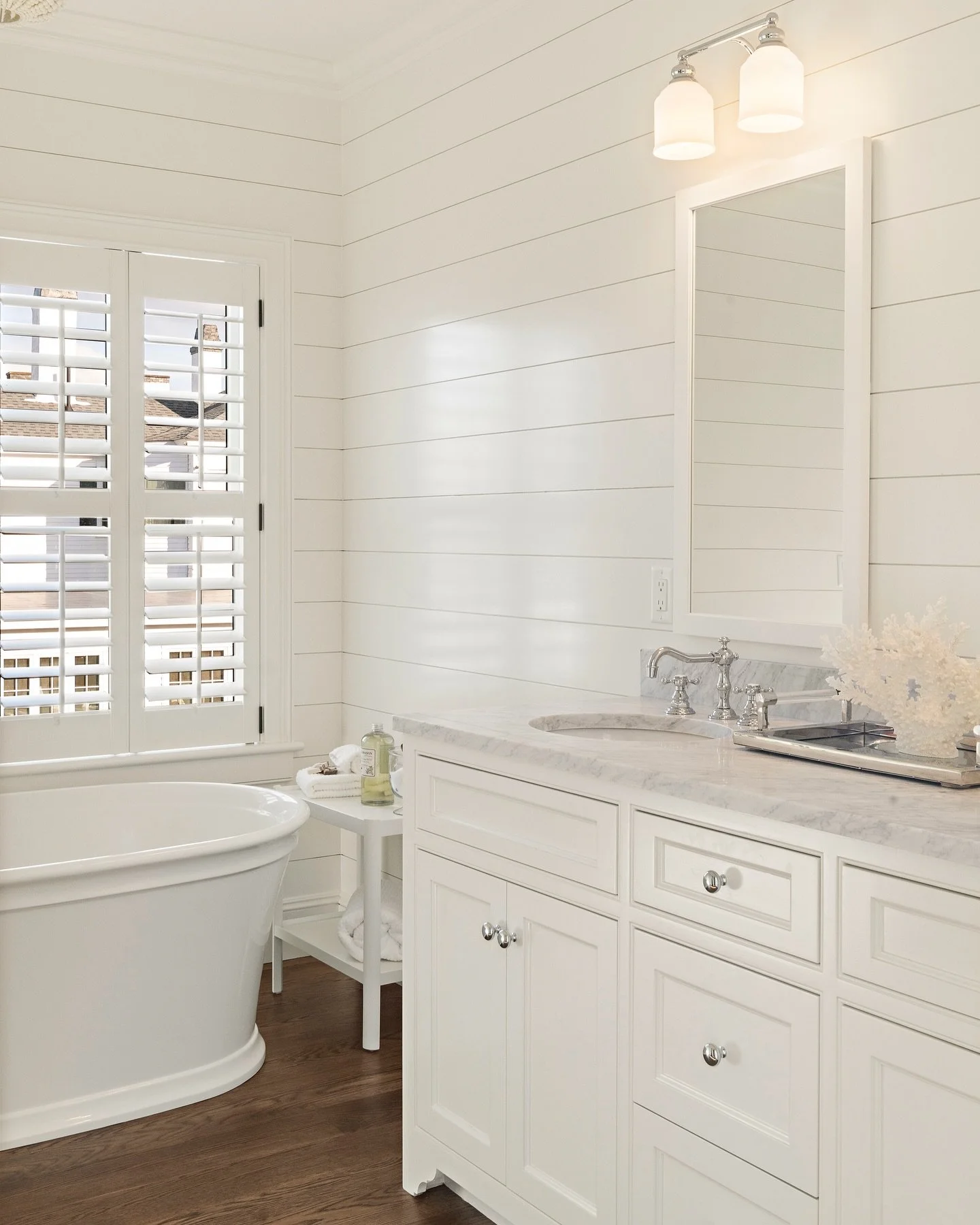 Built to stand the test of time with a refined, coastal aesthetic. This primary bath features custom inset cabinetry, honed marble countertops, and a freestanding soaking tub framed by nickel gap paneling and natural light. 

#bathroom #bathroomdesig