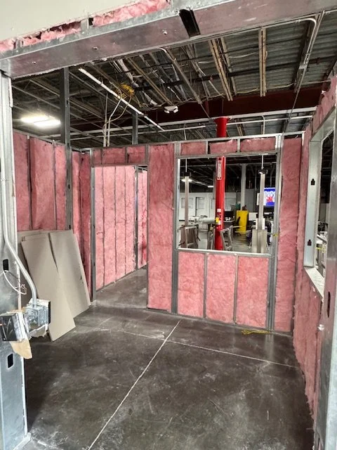 Construction site with pink insulation panels and metal framing for a new room or office.