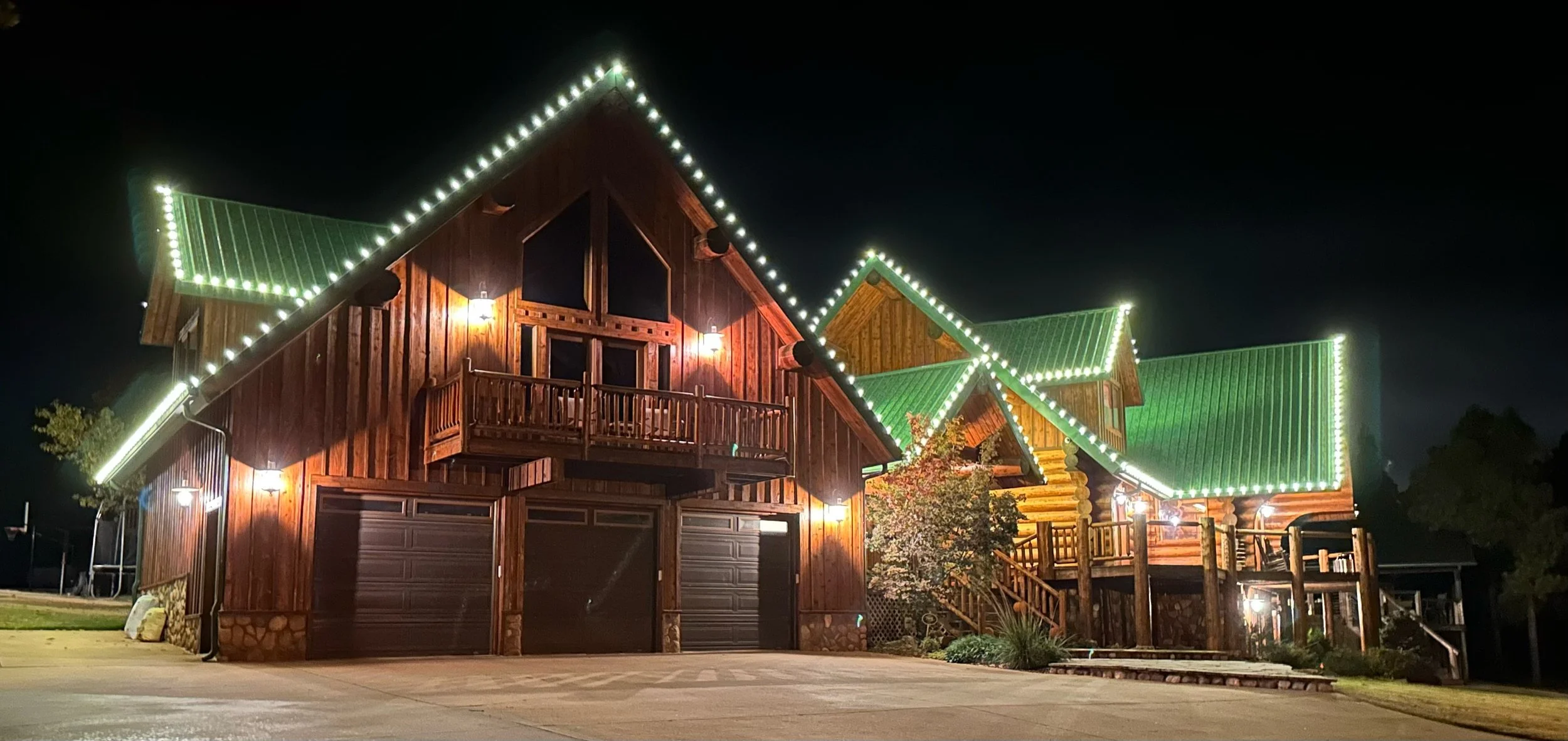 Holiday roofline lighting on a log cabin home in Guthrie, Oklahoma, installed by First Line Services