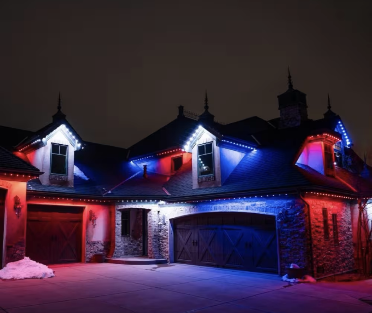 Permanent color-changing roofline lighting in red and blue on a residential home.