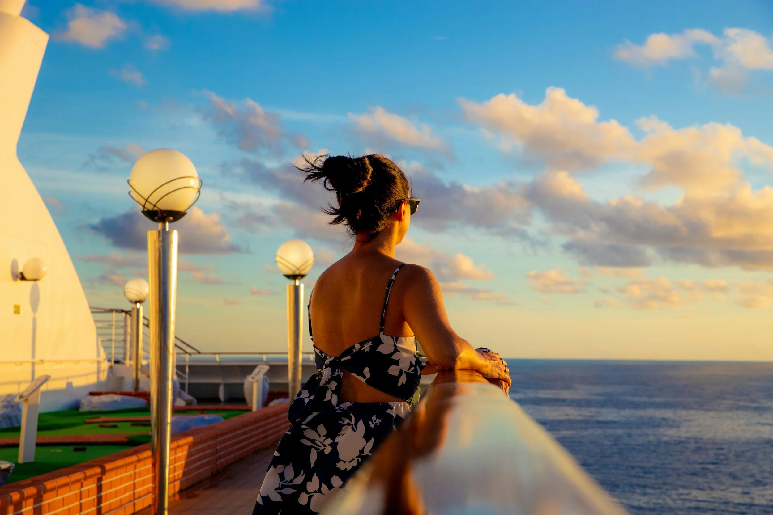 Women enjoy the peaceful breeze on her cruise voyage while her family enjoys the kids clubs, entertainment and buffet lines of the ship. All planning done in advance, now time to relax.