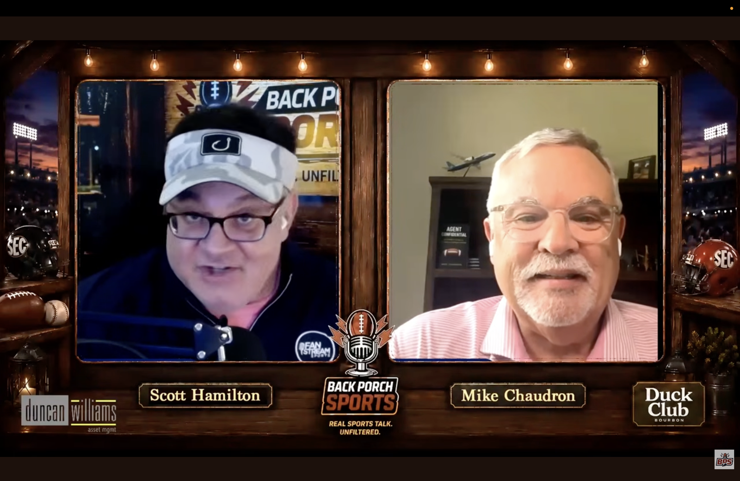 Screenshot of a video call featuring two men, Scott Hamilton on the left wearing glasses and a baseball cap, and Mike Chaudron on the right with glasses and gray hair. The background includes sports memorabilia, helmets, and football-themed decorations.