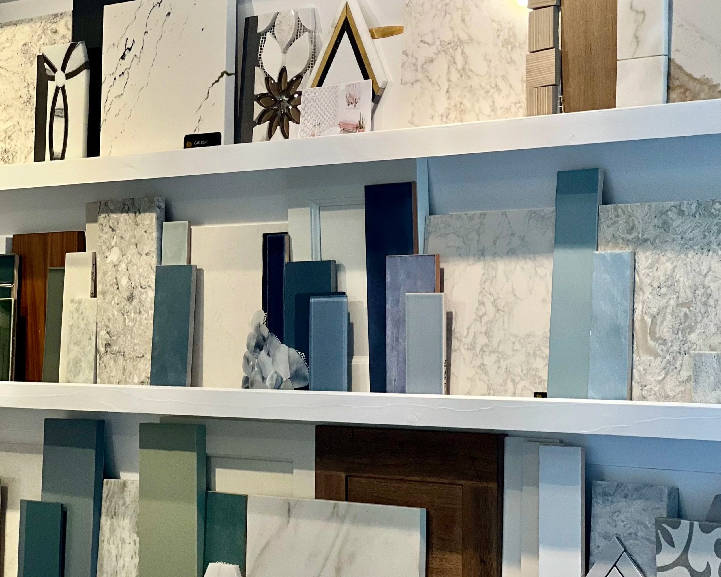 Display of various types and colors of marble and stone samples arranged on shelves in a store or showroom.